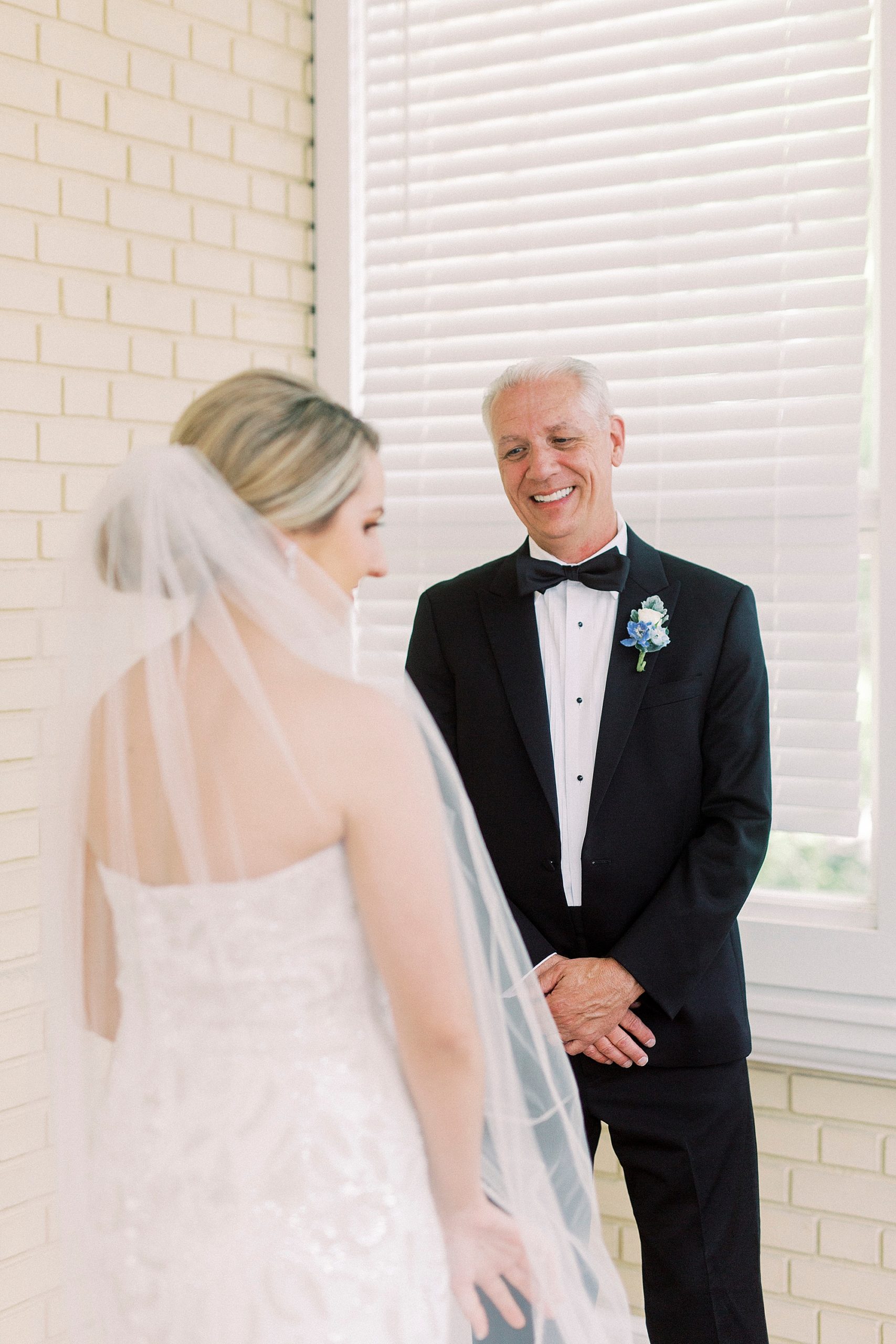 dad smiles looking at bride during first look