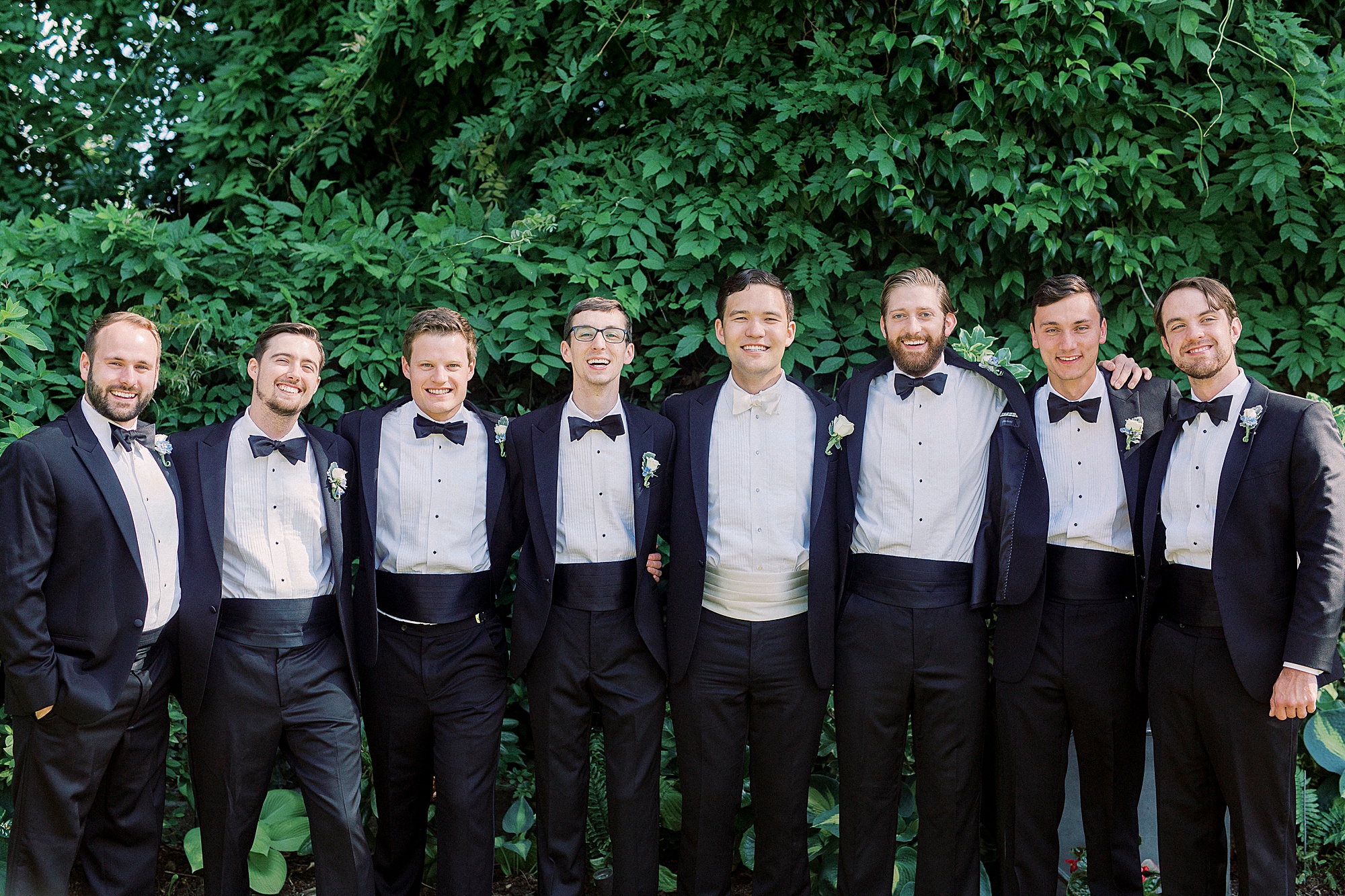 groomsmen in black suits hug