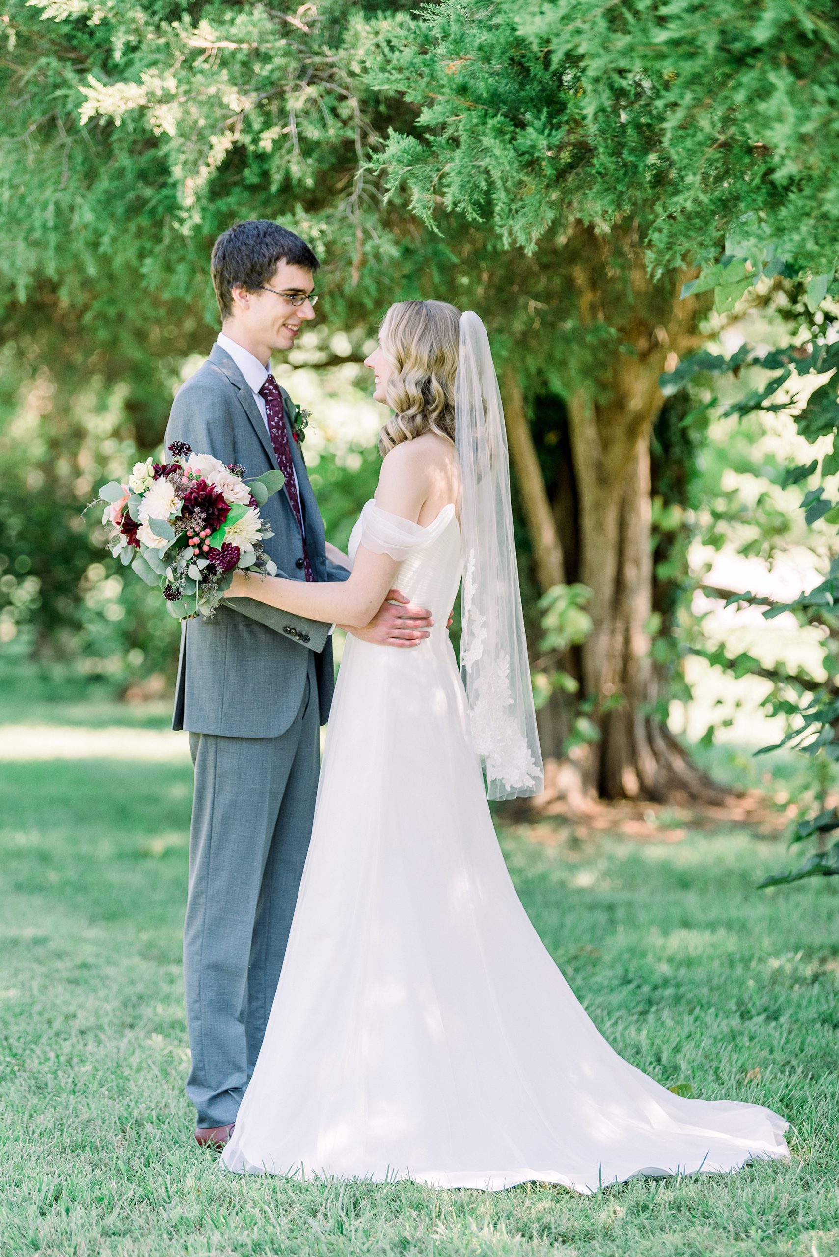 bride looks at groom during first look