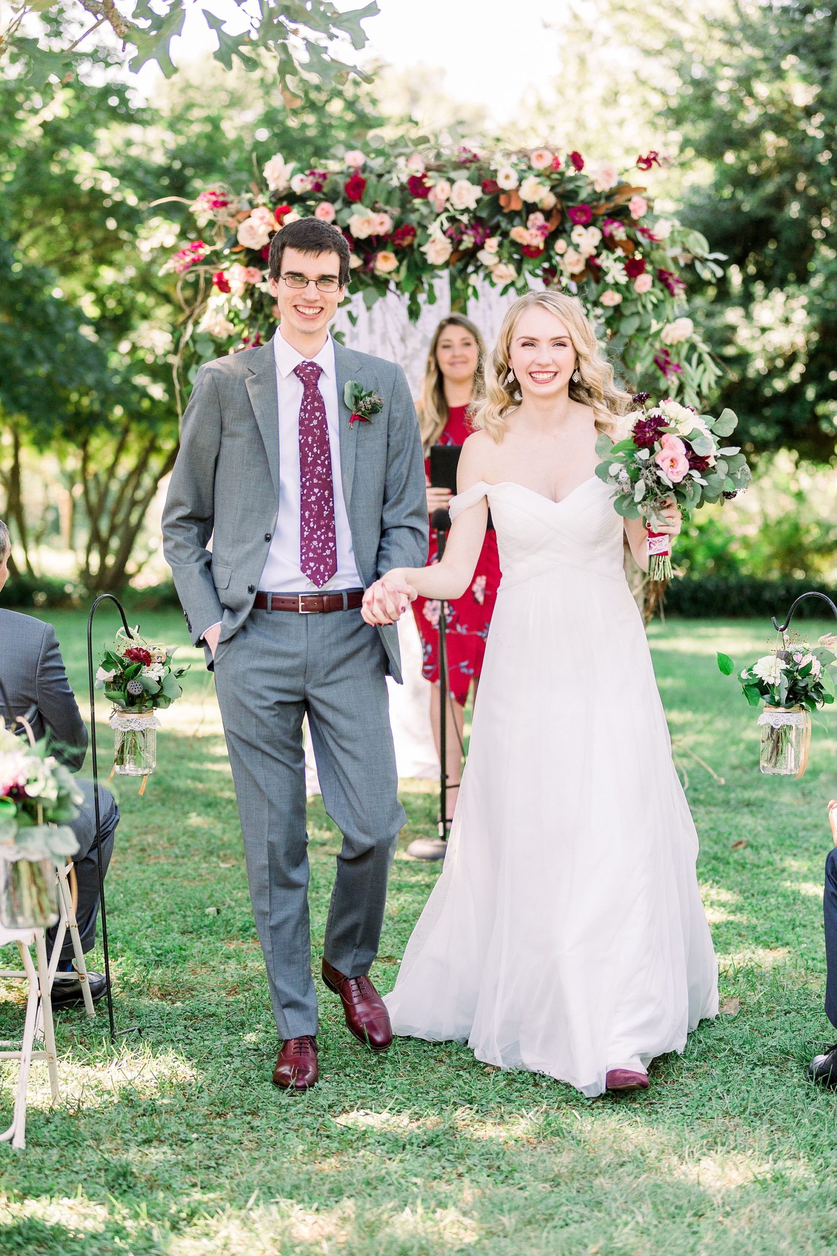 bride and groom smile leaving wedding ceremony