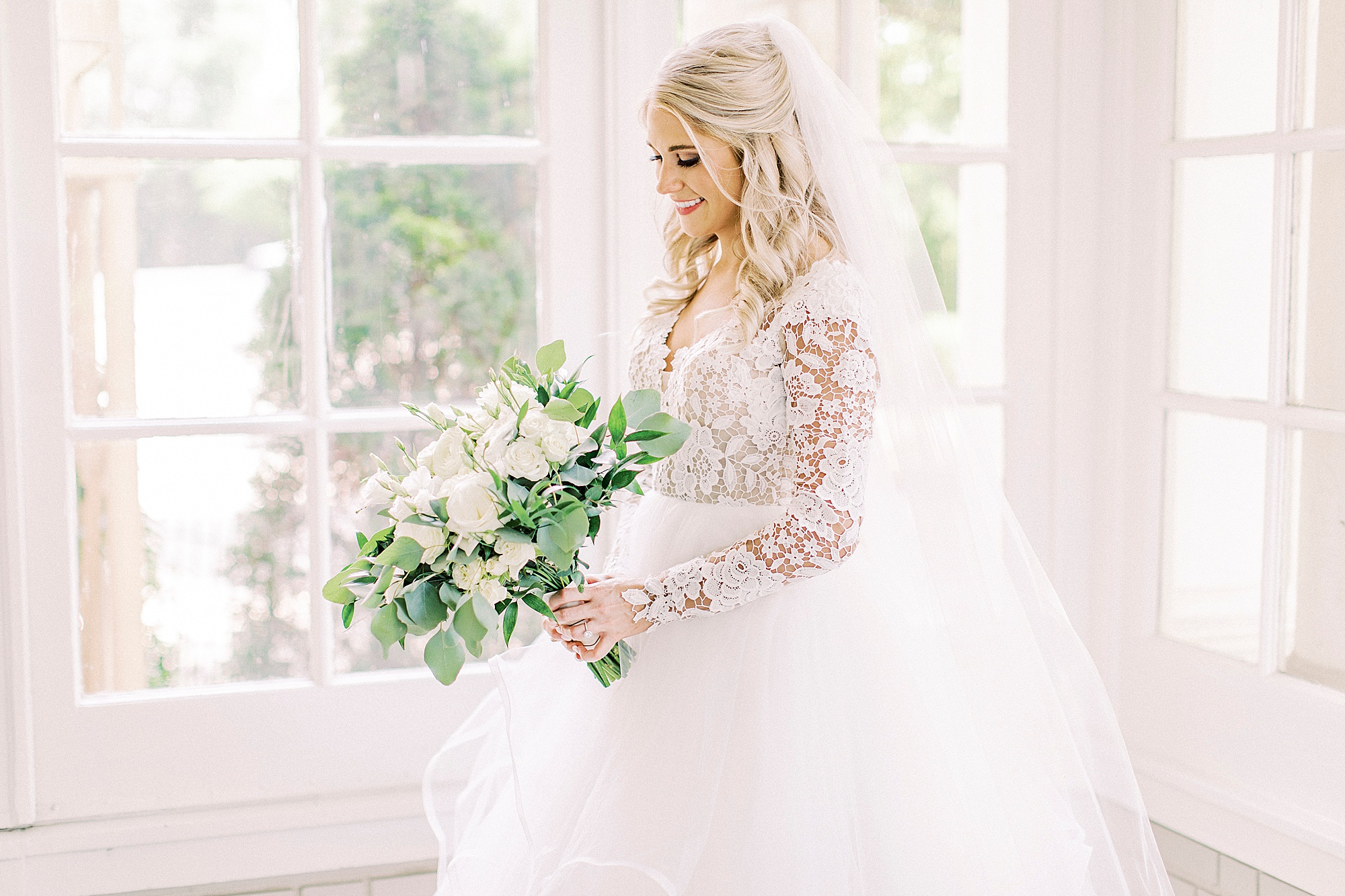 bride holds bouquet in window of Separk Mansion