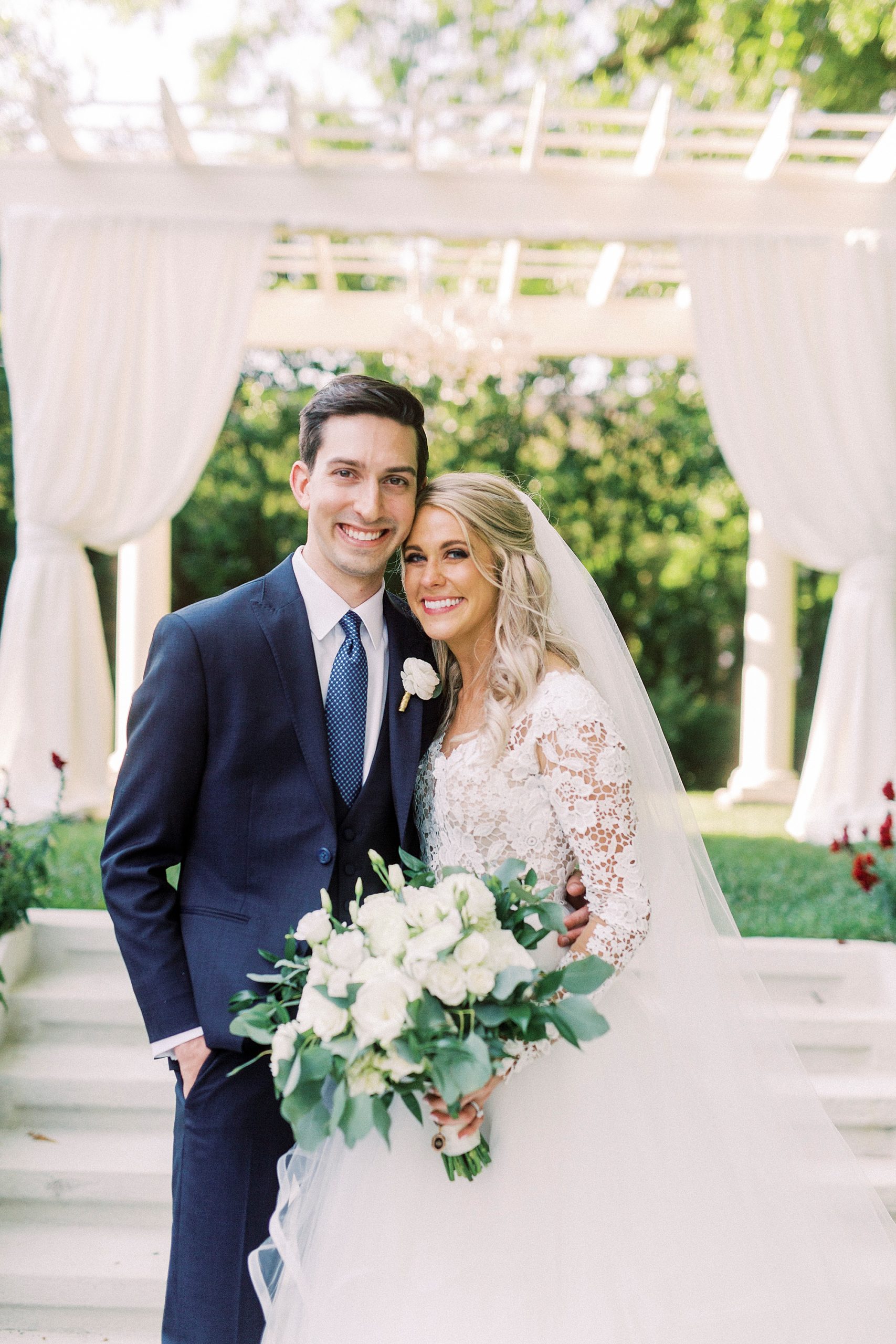 newlyweds pose by arbor after garden wedding ceremony at Separk Mansion