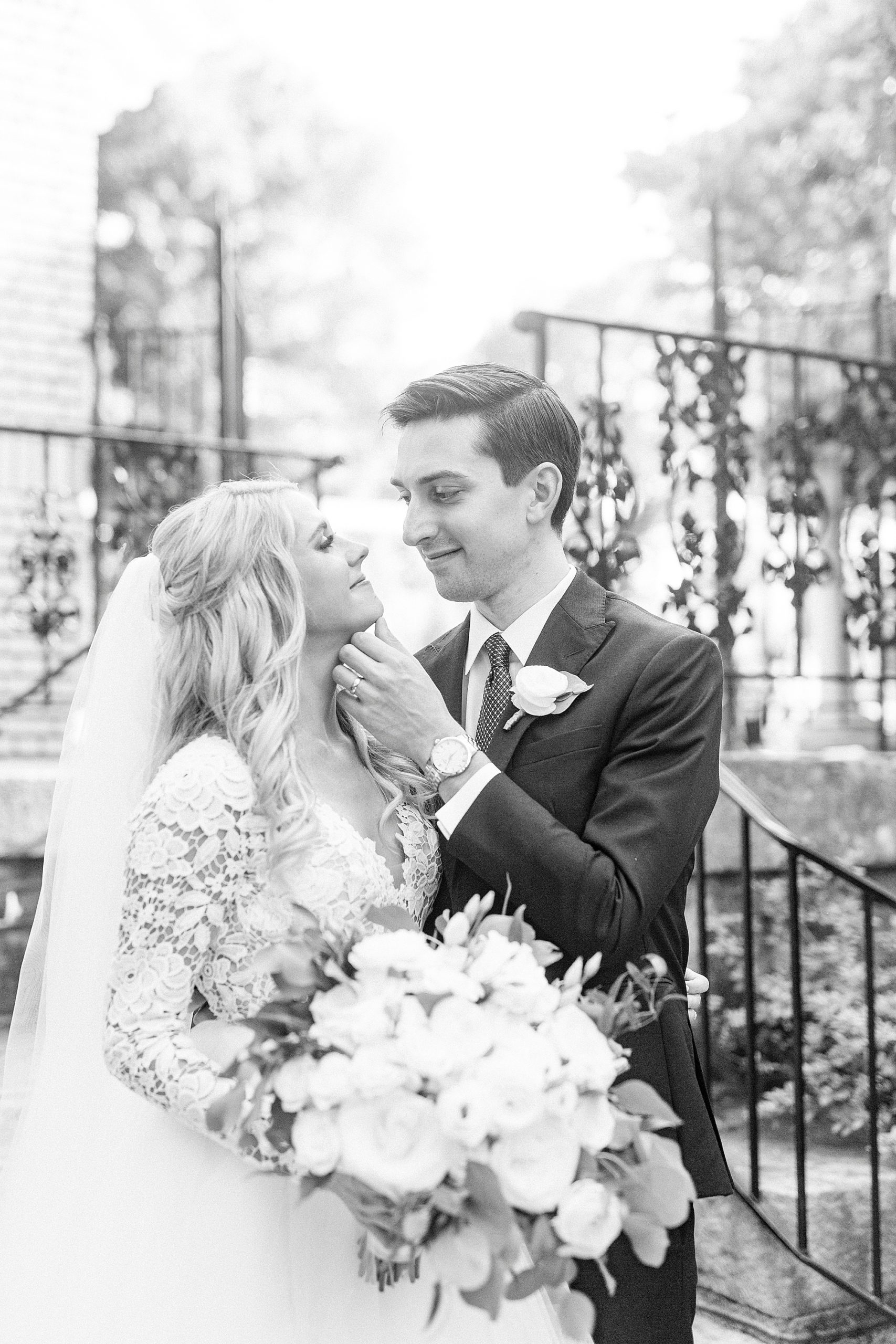 groom looks at bride touching her chin