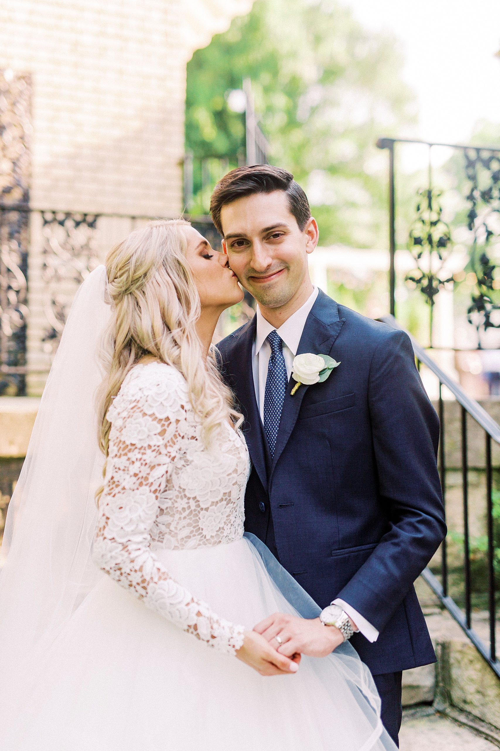 bride in Hayden Olivia bridal gown kisses groom's cheek