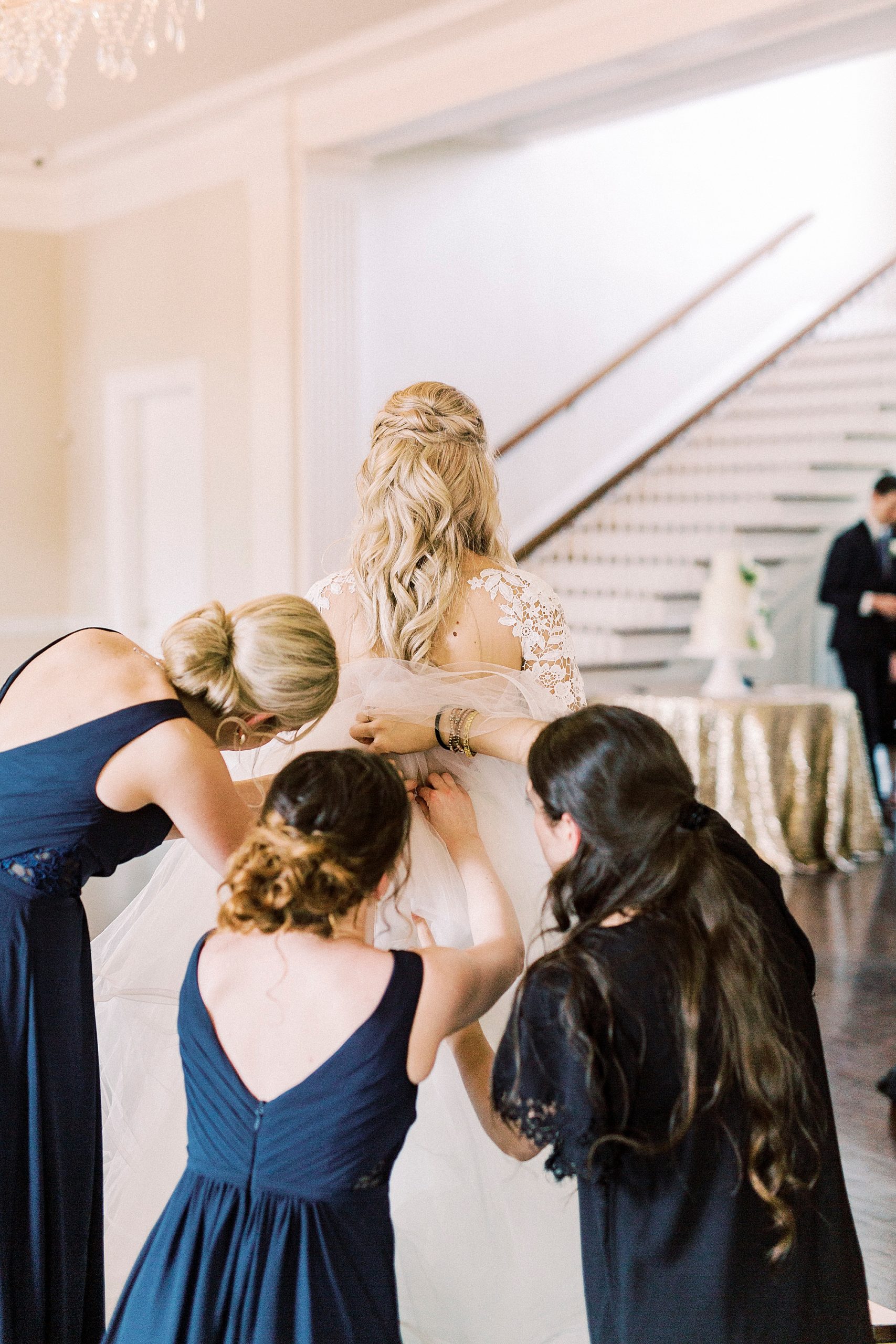 bridesmaids help bustle Hayden Olivia bridal gown for bride