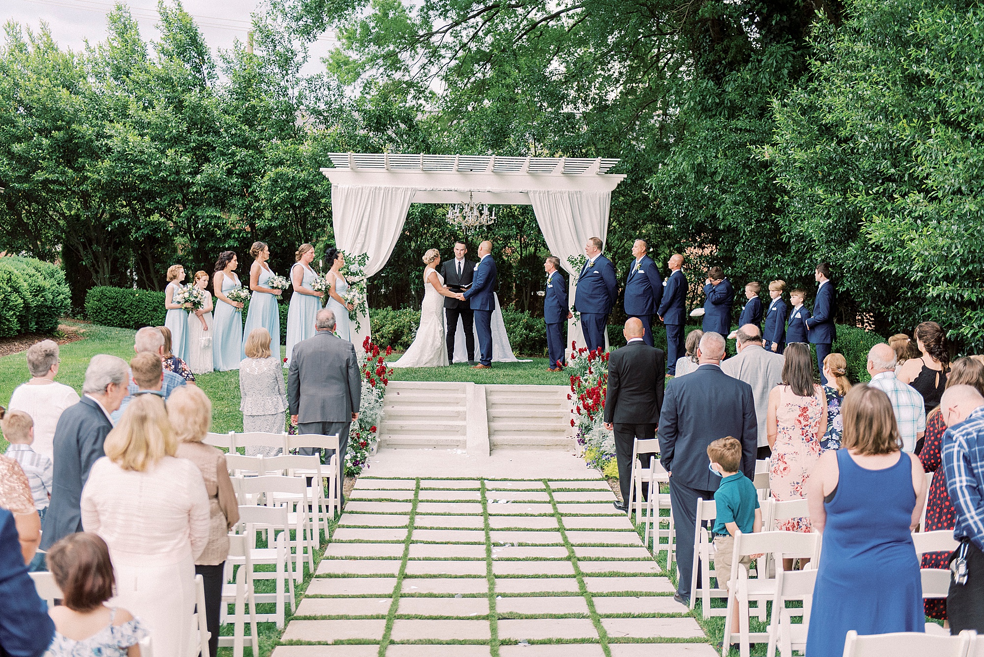 newlyweds hold hands during garden ceremony in Charlotte NC