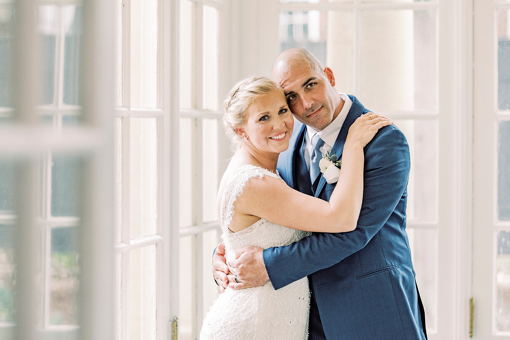 newlyweds hug in corner of patio space at Separk Mansion