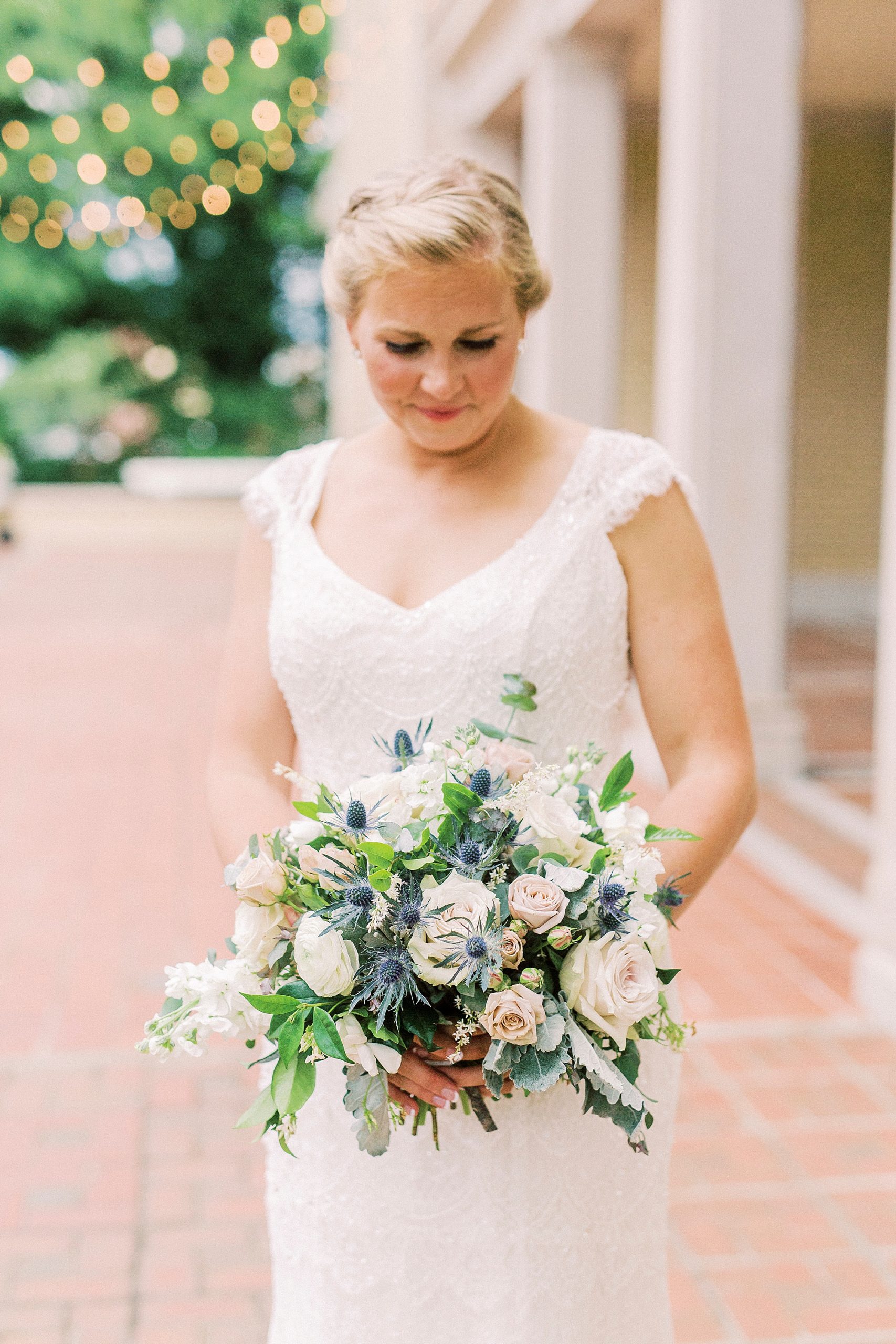 bride holds bouquet of white and pink flowers outside Separk Mansion