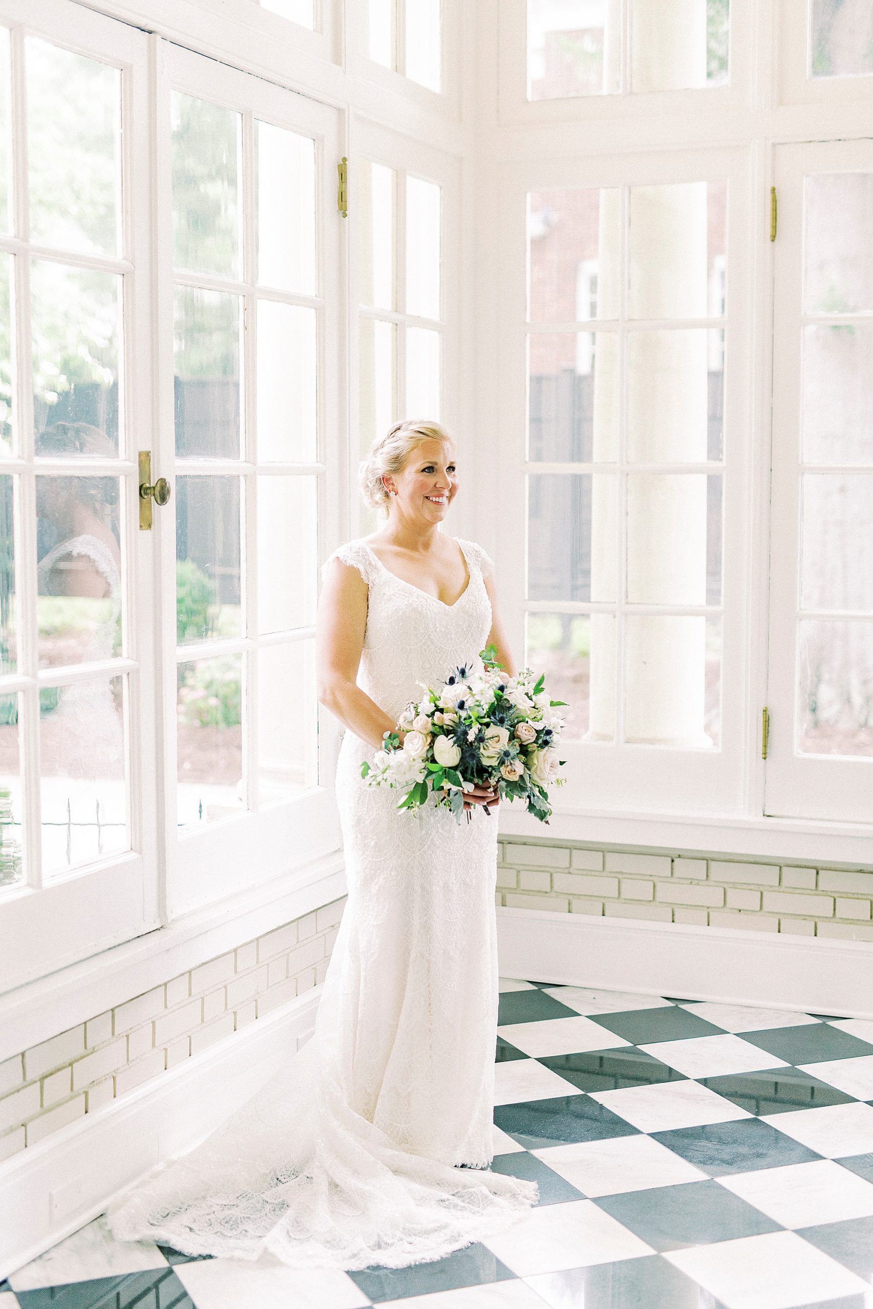 bride poses in corner of room with black and white tiles