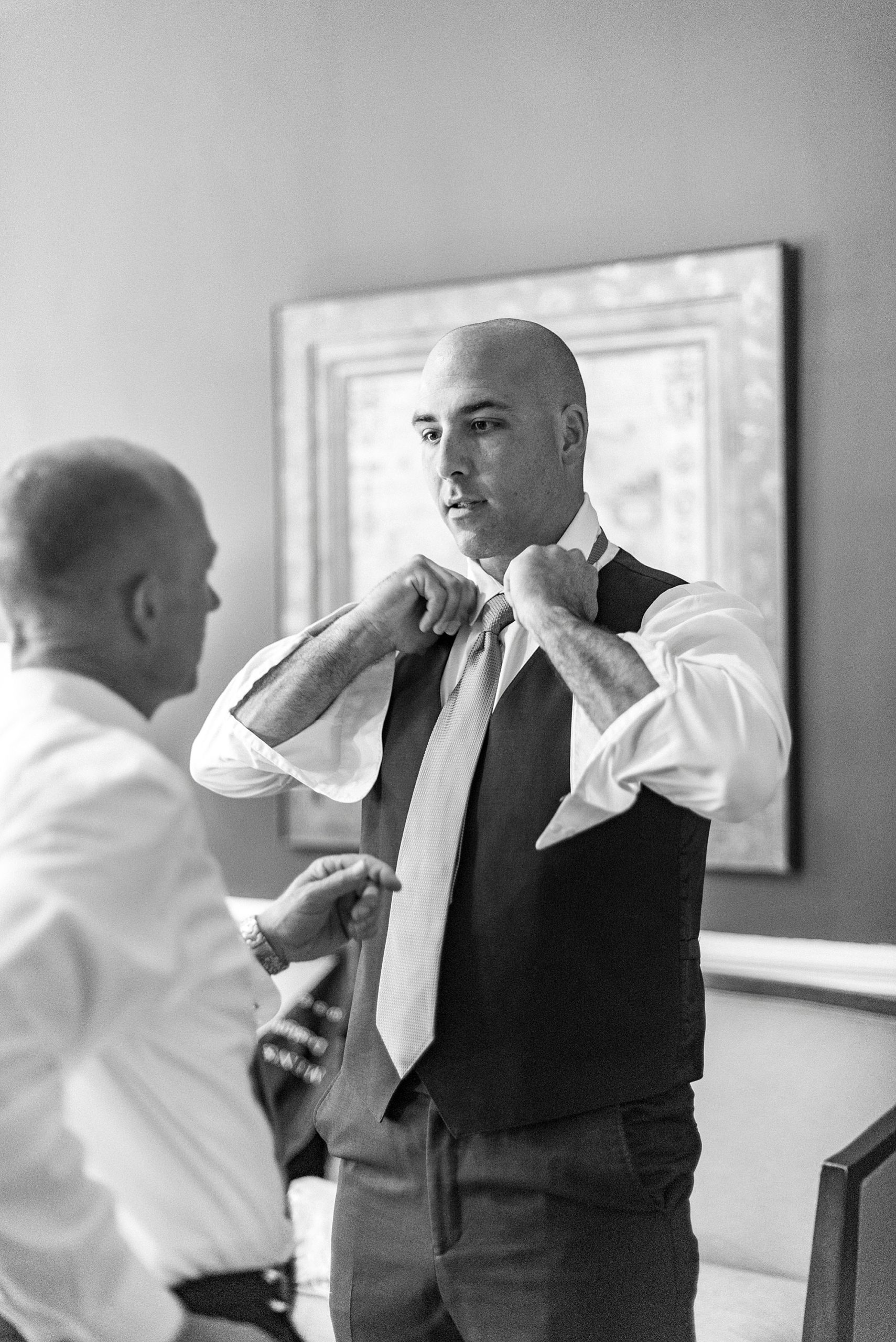 groom prepares for NC wedding day with groomsman