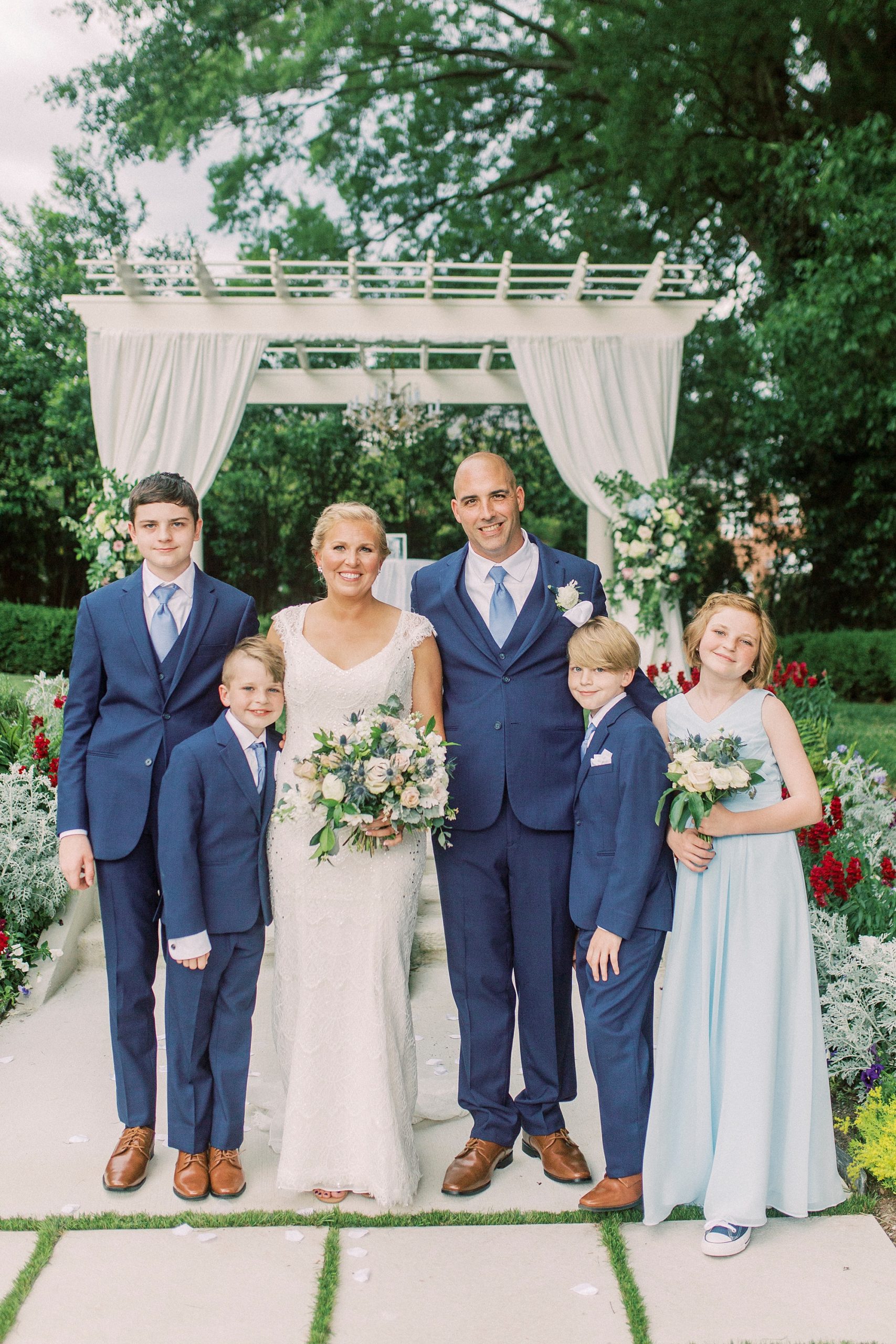 bride and groom pose with four kids after sand ceremony for family during Separk Mansion wedding ceremony