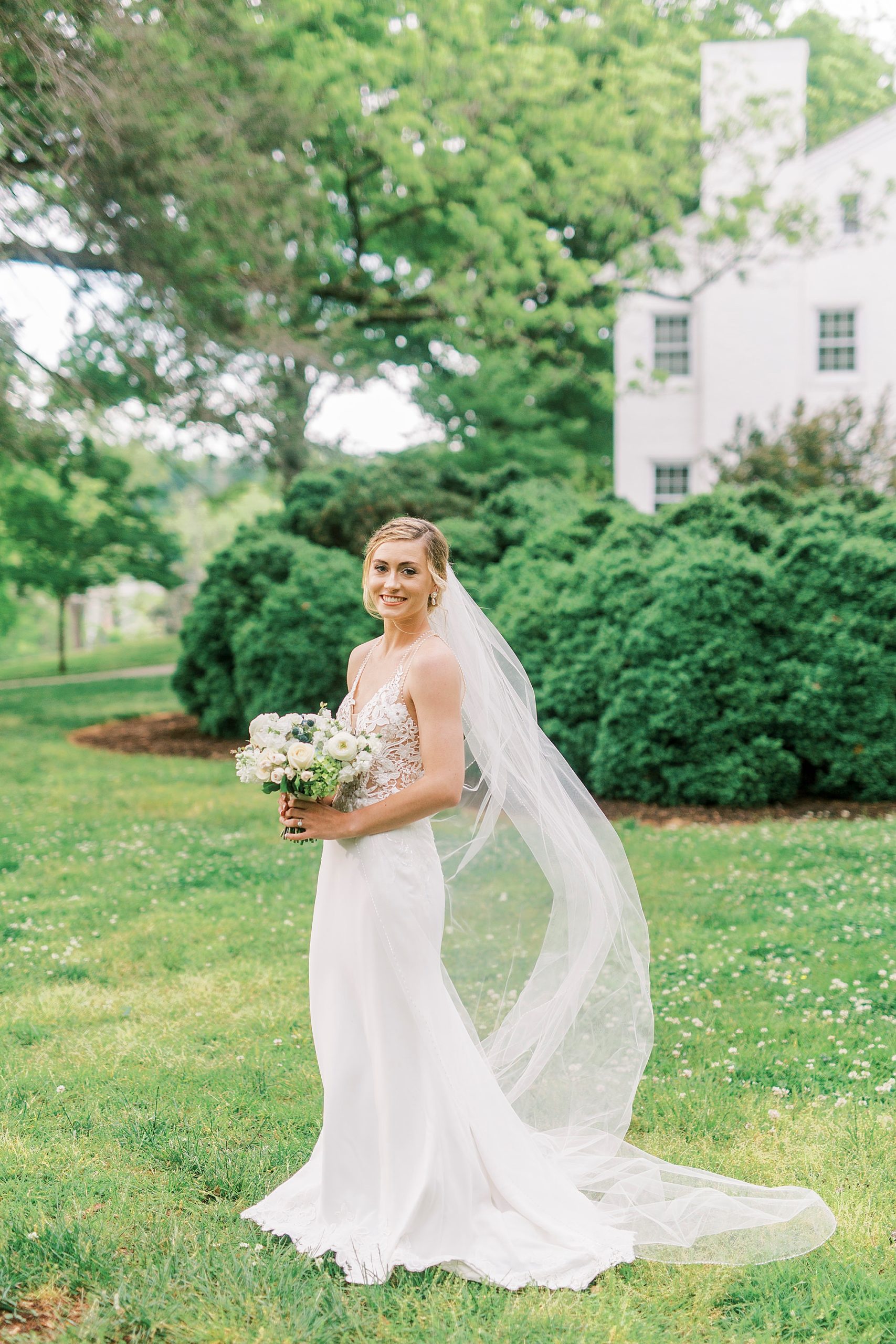 bride holds bouquet with veil behind her