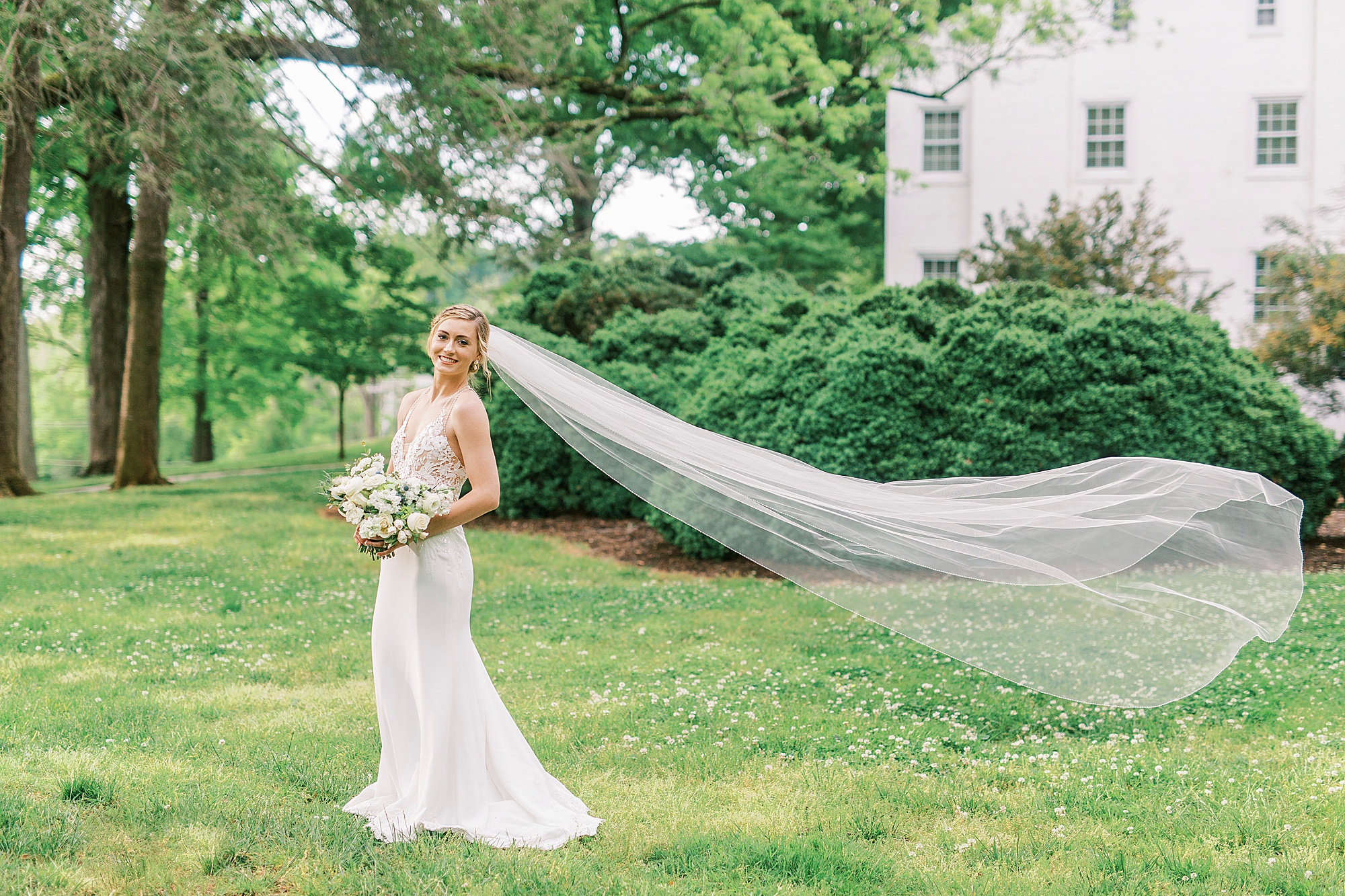bride smiles with veil floating behind her during Tanglewood bridal portraits