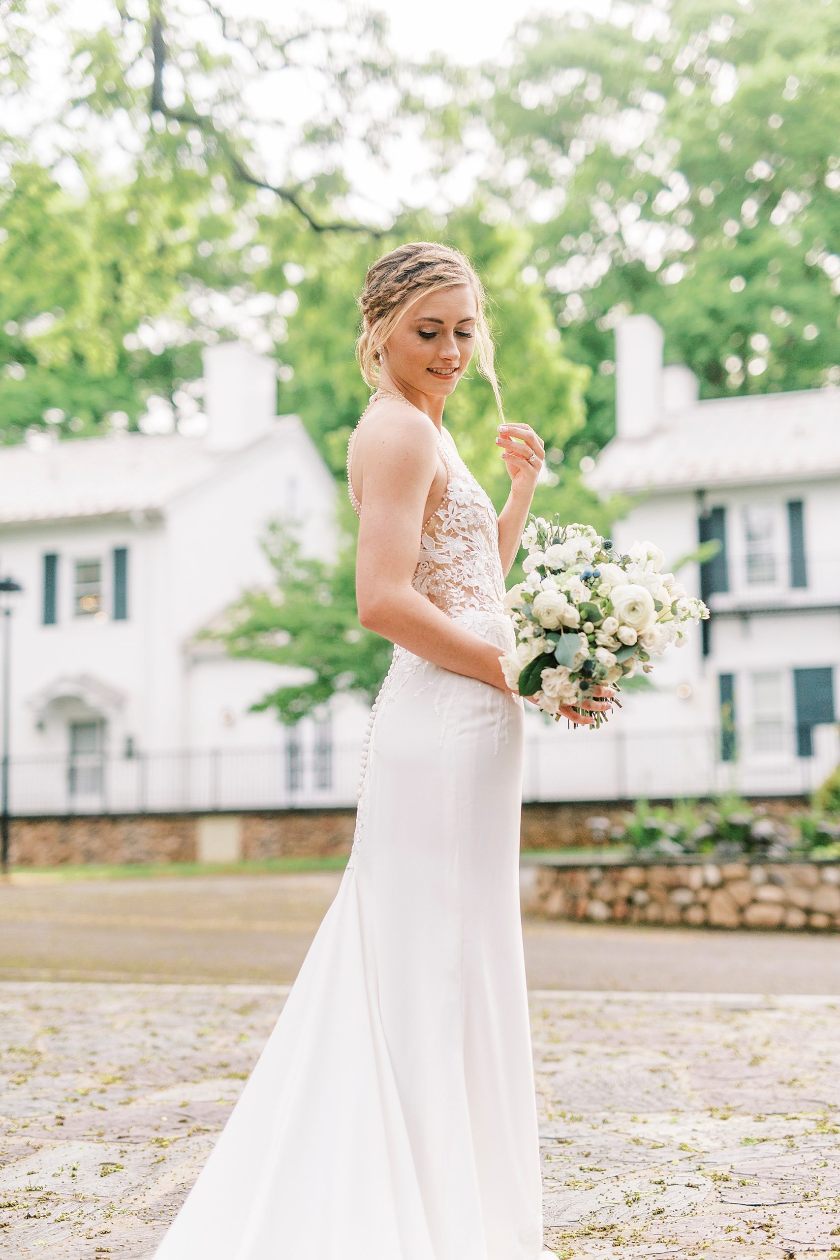 bride holds hair looking down at bouquet during Tanglewood bridal portraits