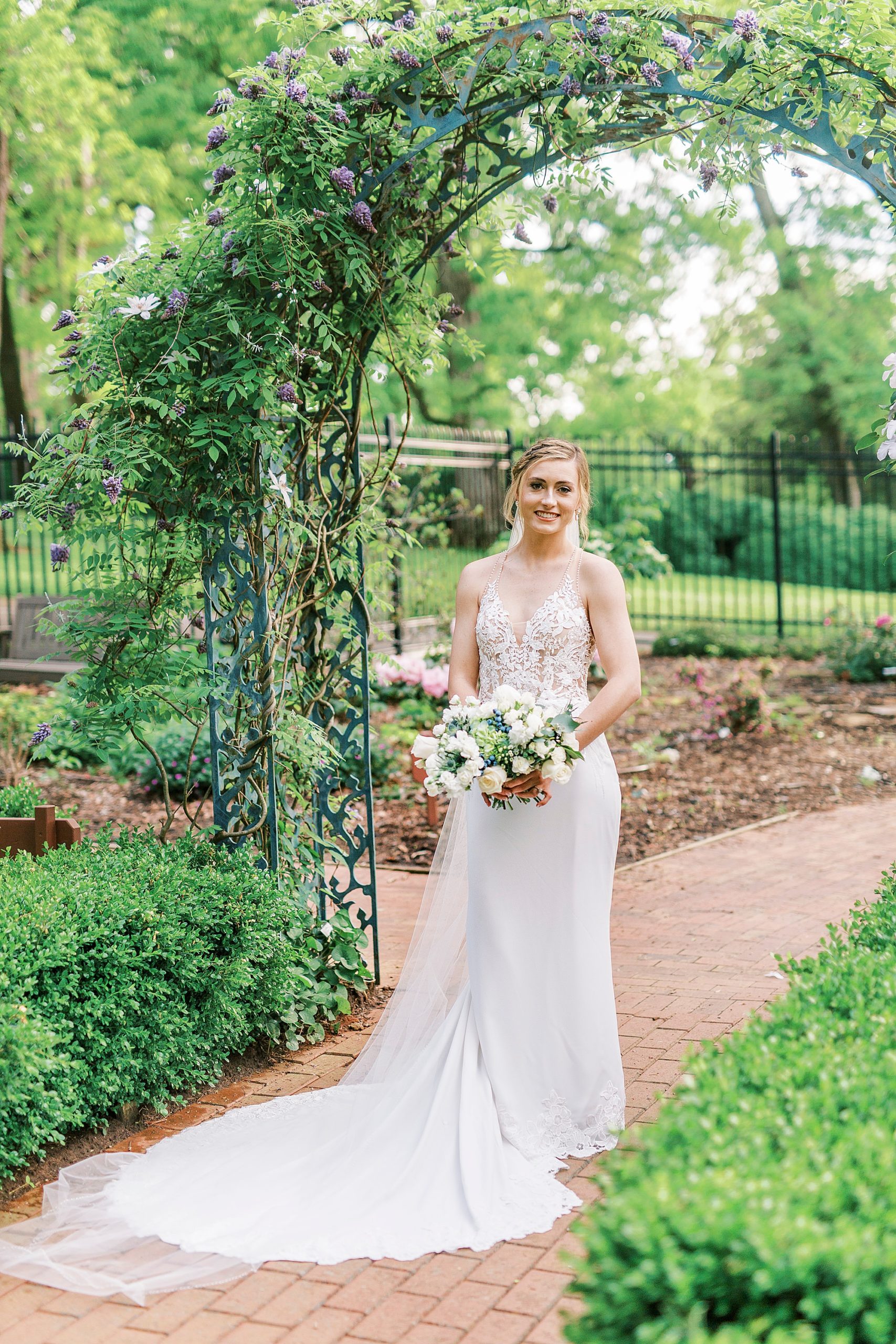 bride walks under arbor at Tanglewood Park