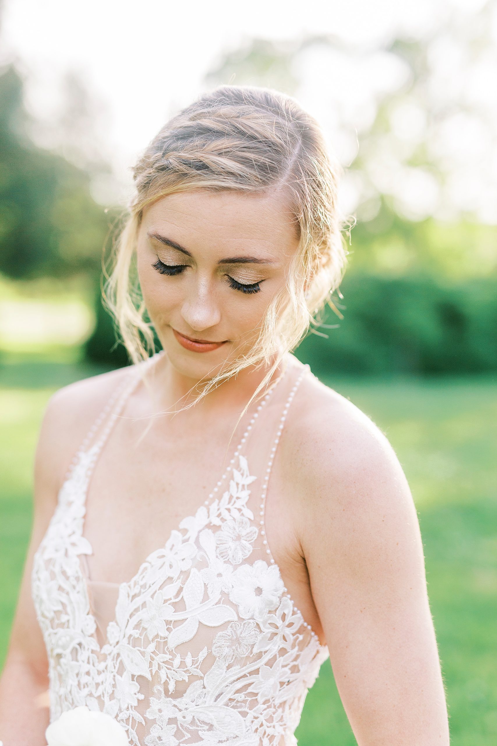 bride closes eyes looking down at bouquet