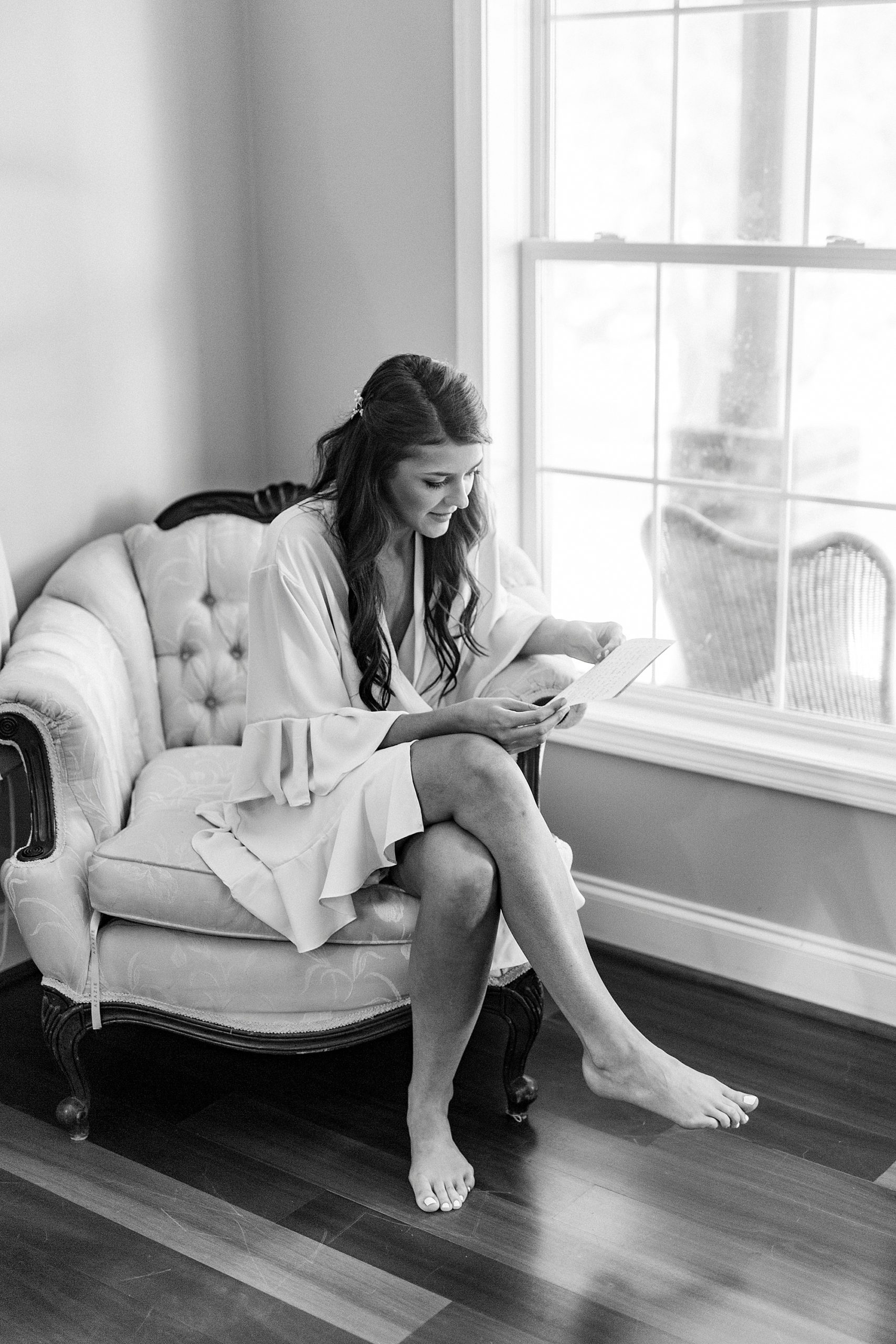 bride reads note on wedding day at The Farmstead