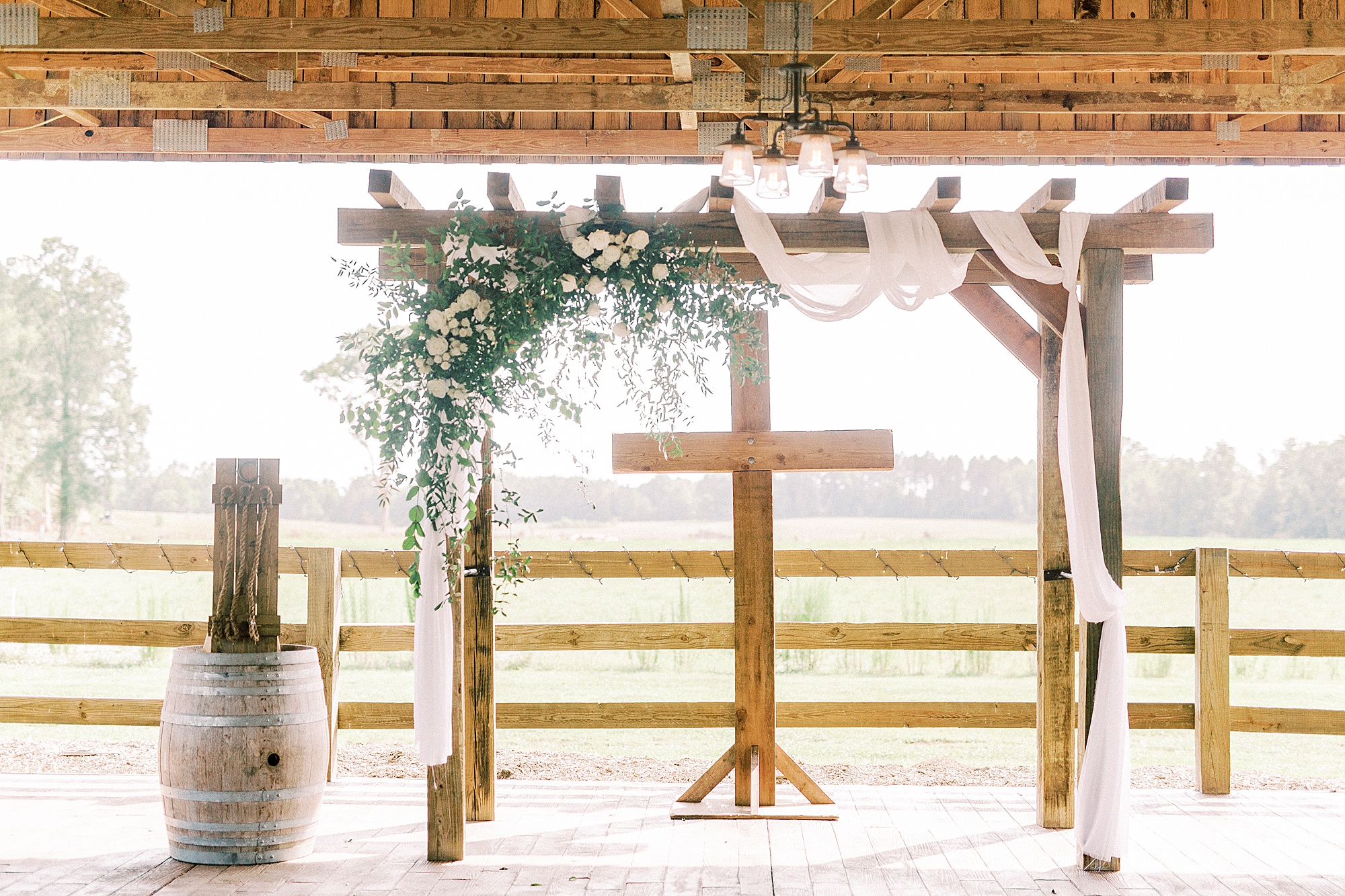 rustic wedding ceremony by wooden cross at The Farmstead