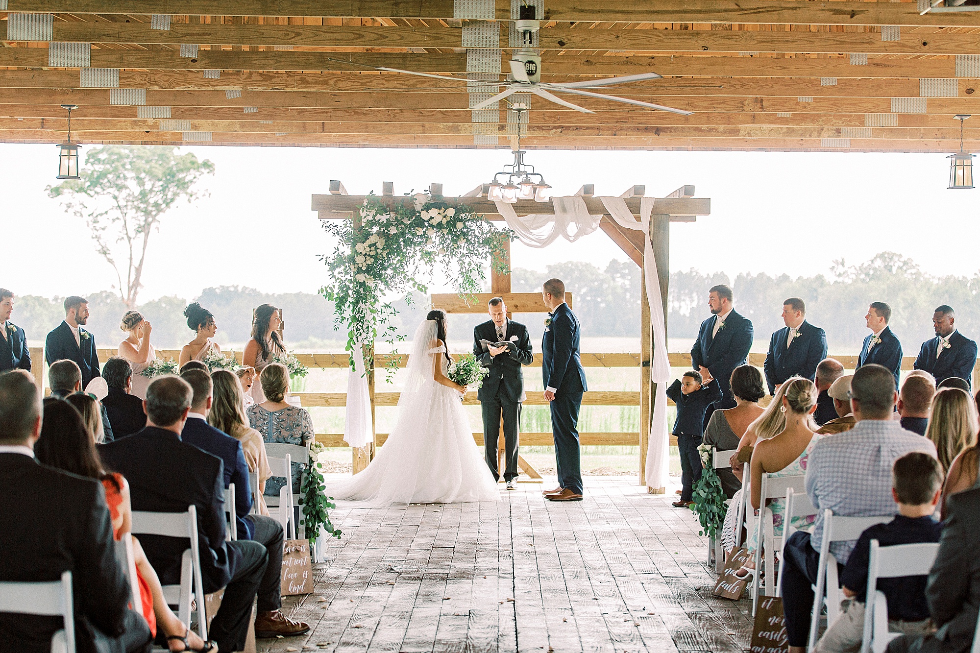 rustic wedding ceremony by wooden cross at The Farmstead