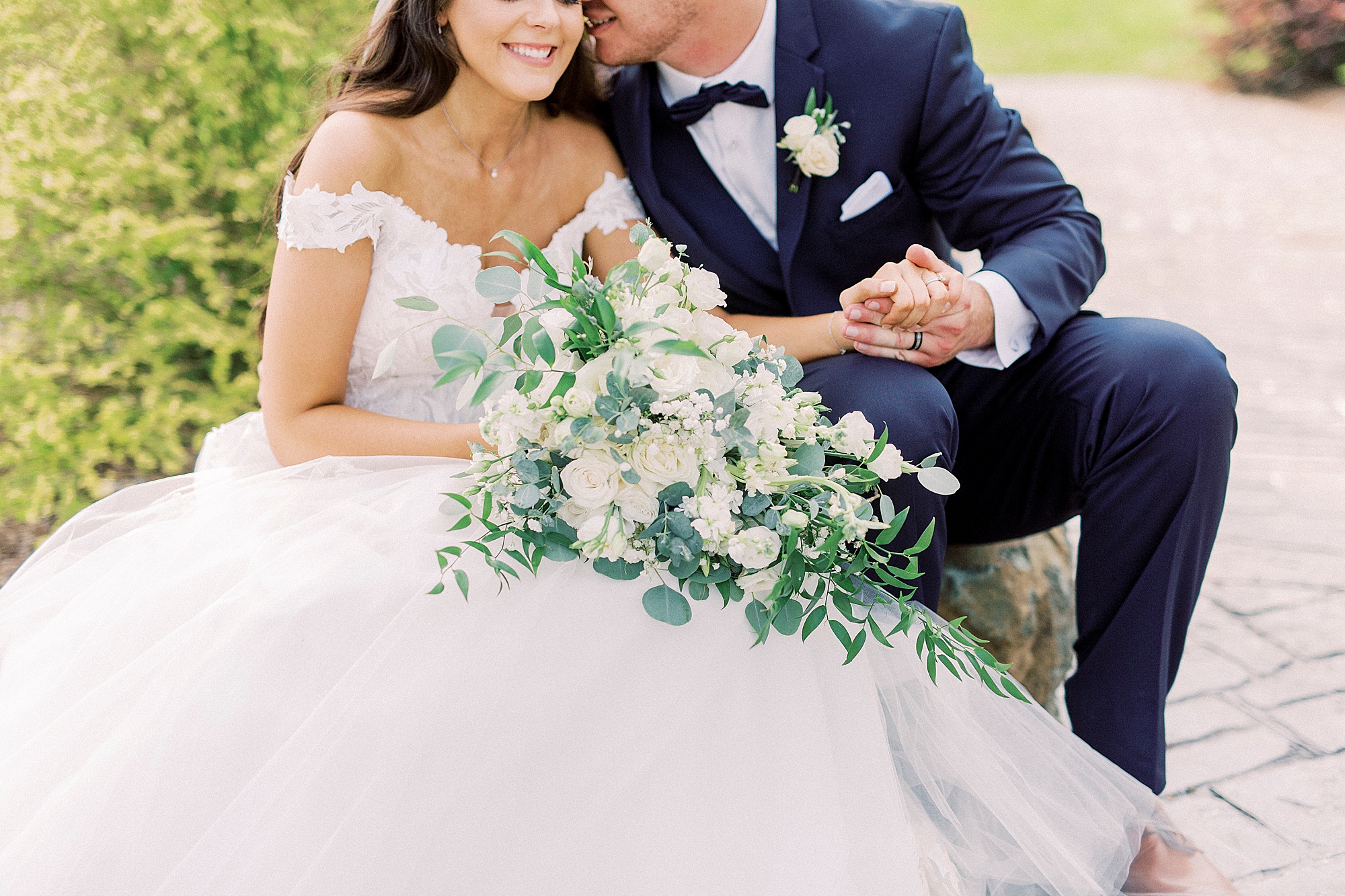 bride and groom hold hands sitting on patio at The Farmstead
