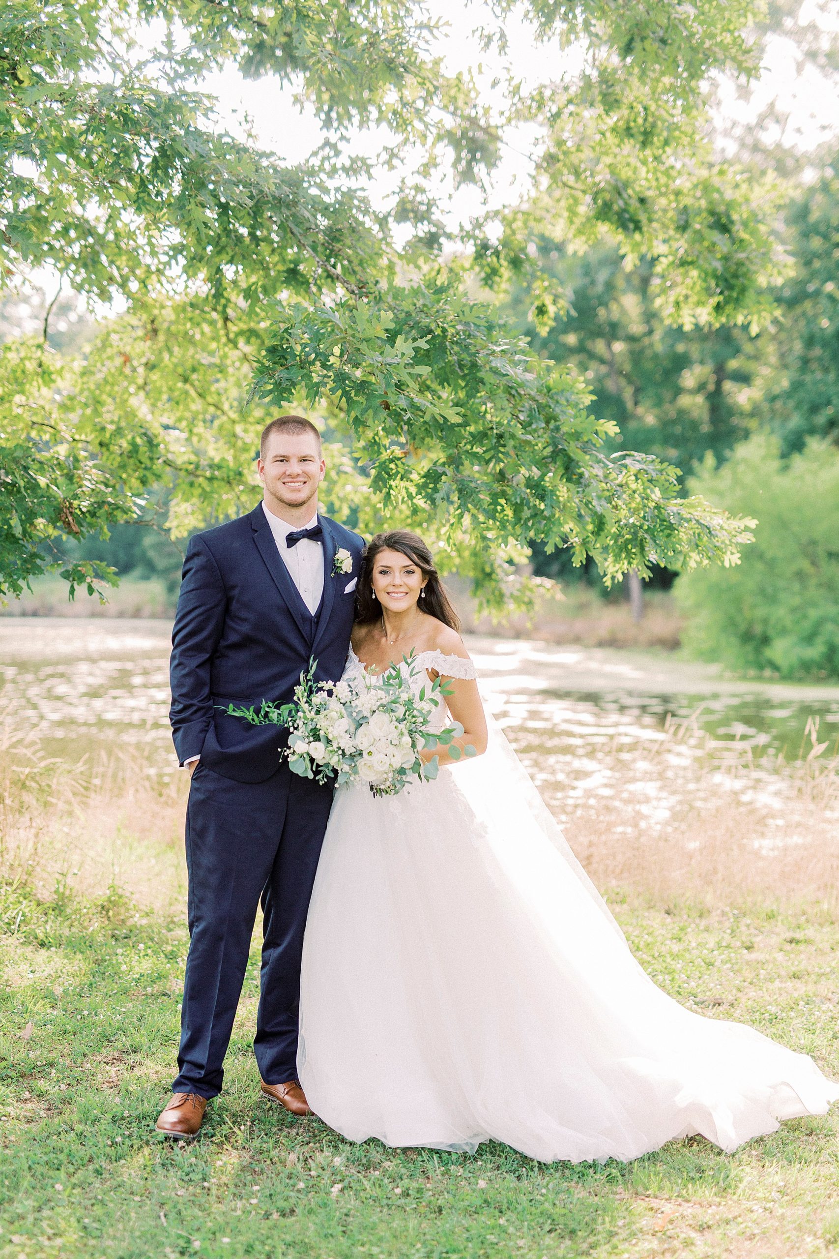 bride and groom pose outside The Farmstead