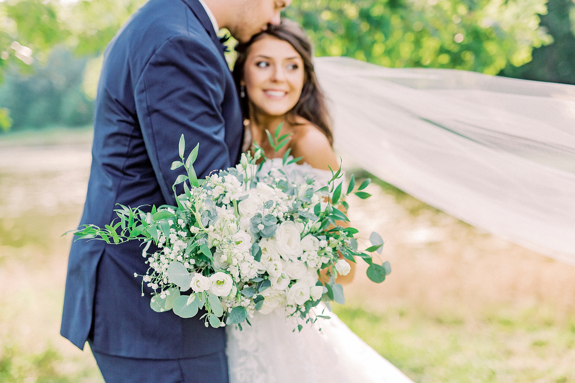 groom kisses bride's head during NC wedding photos