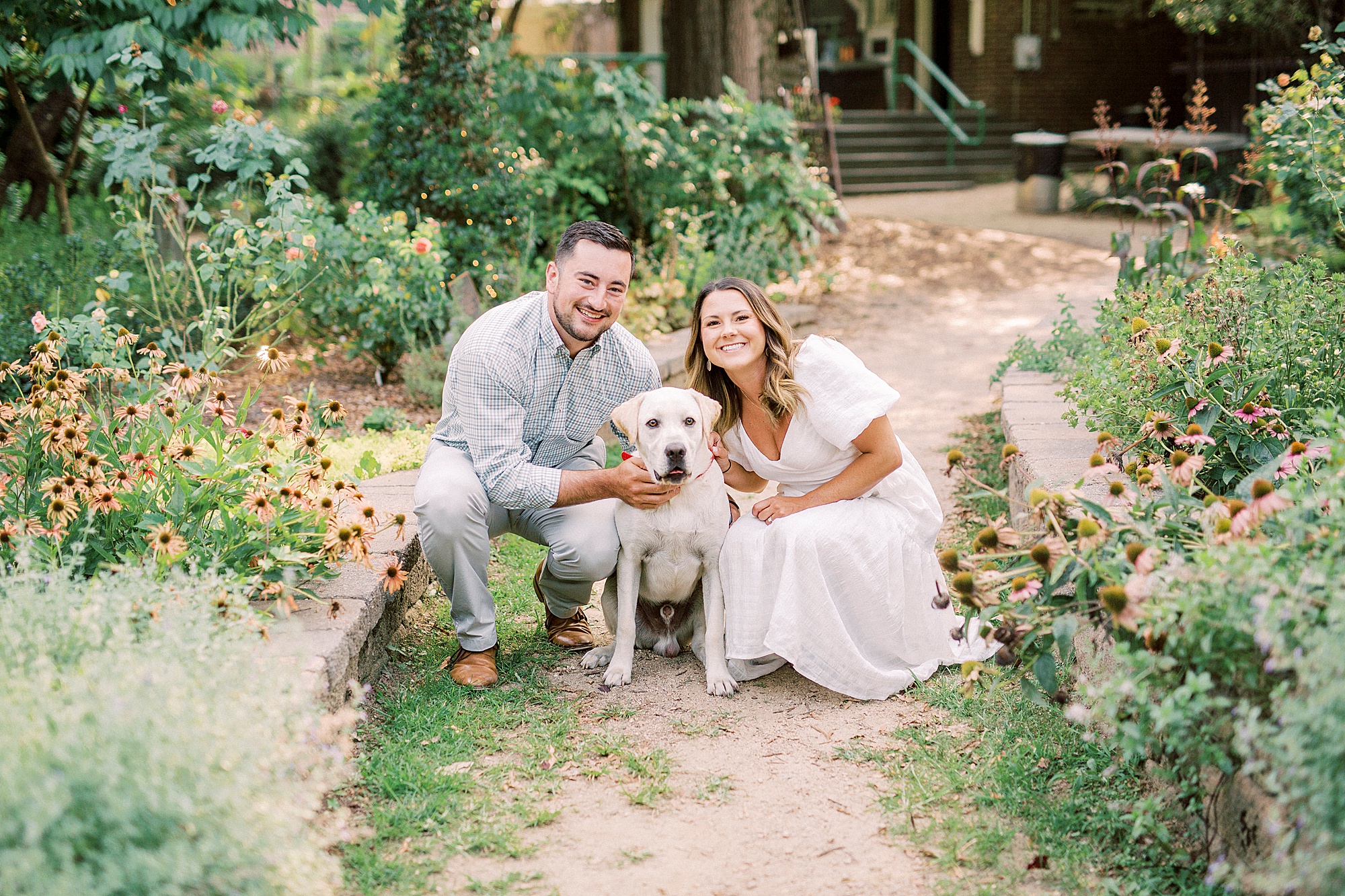 couple poses with dog in McGill Rose Garden