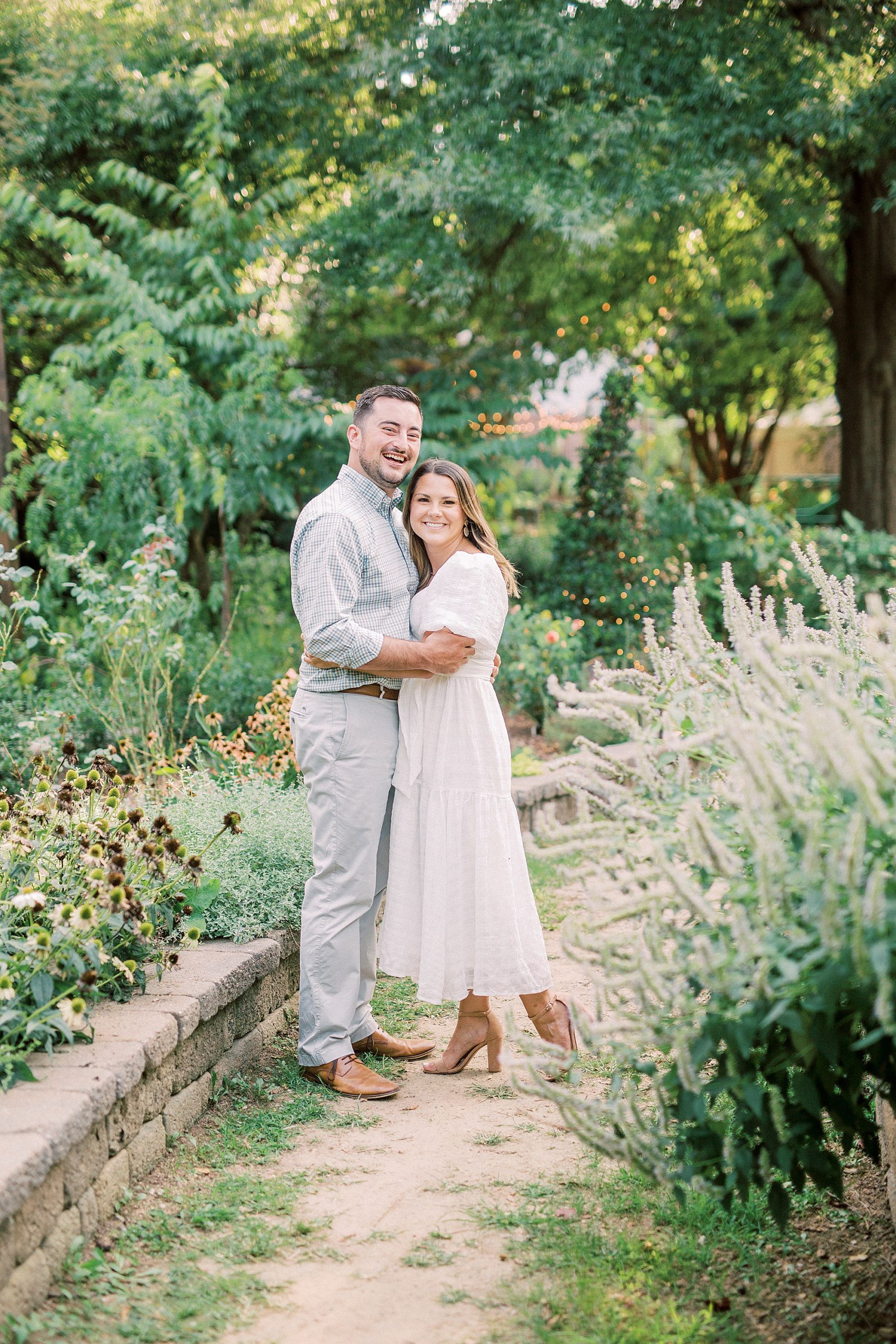 couple hugs on pathway in Charlotte garden