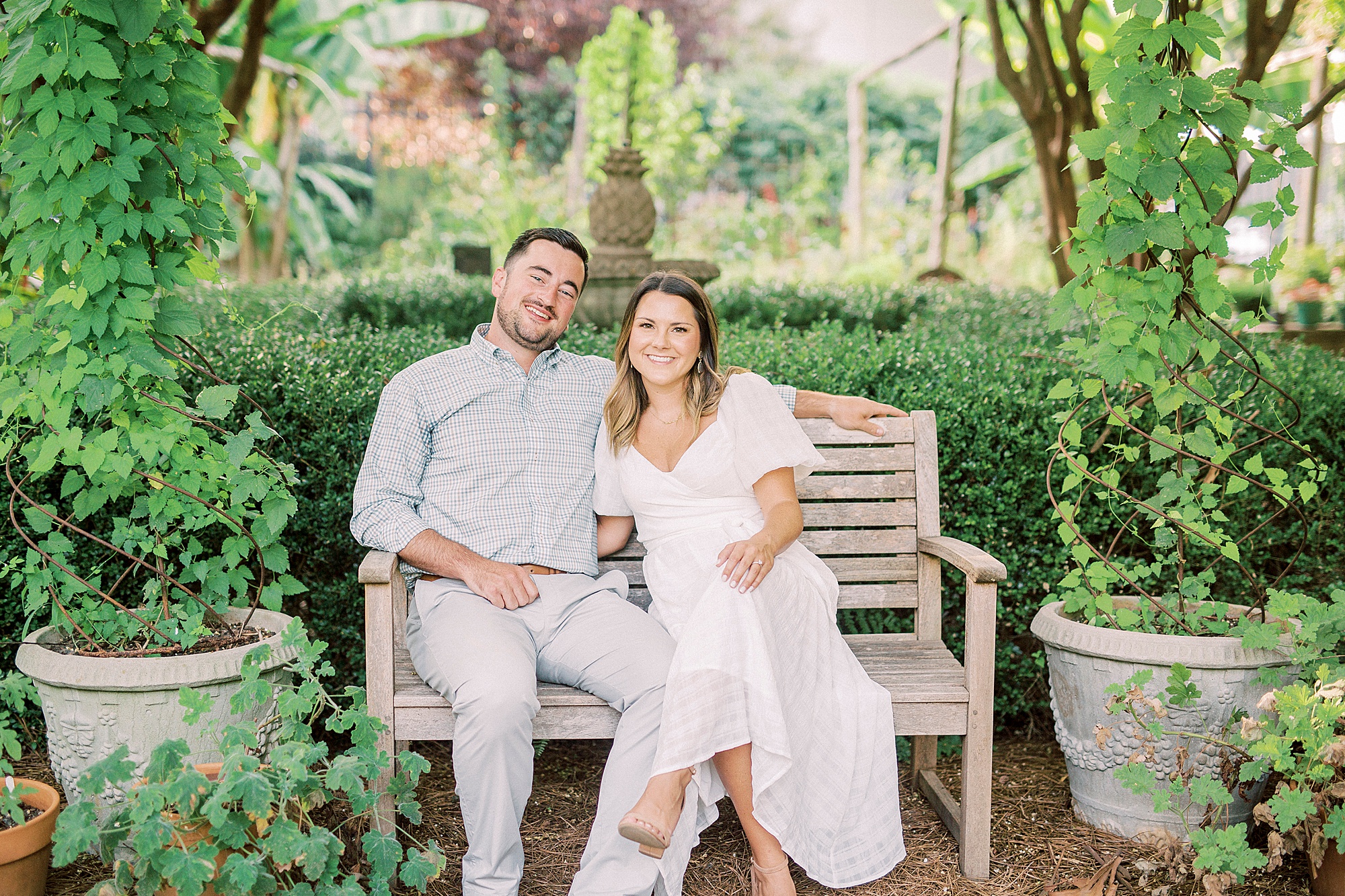bride and groom sit on bench in McGill Rose Garden