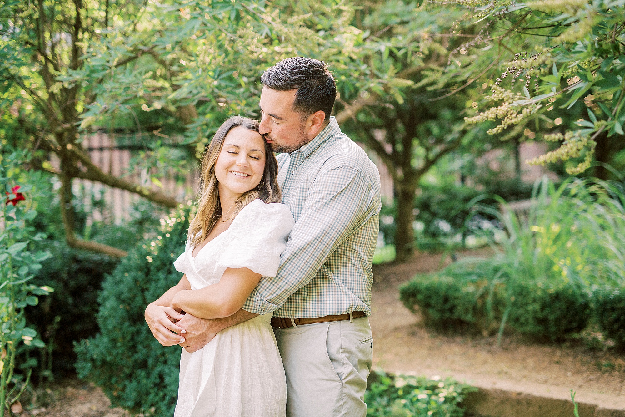 groom kisses bride's forehead during engagement photos