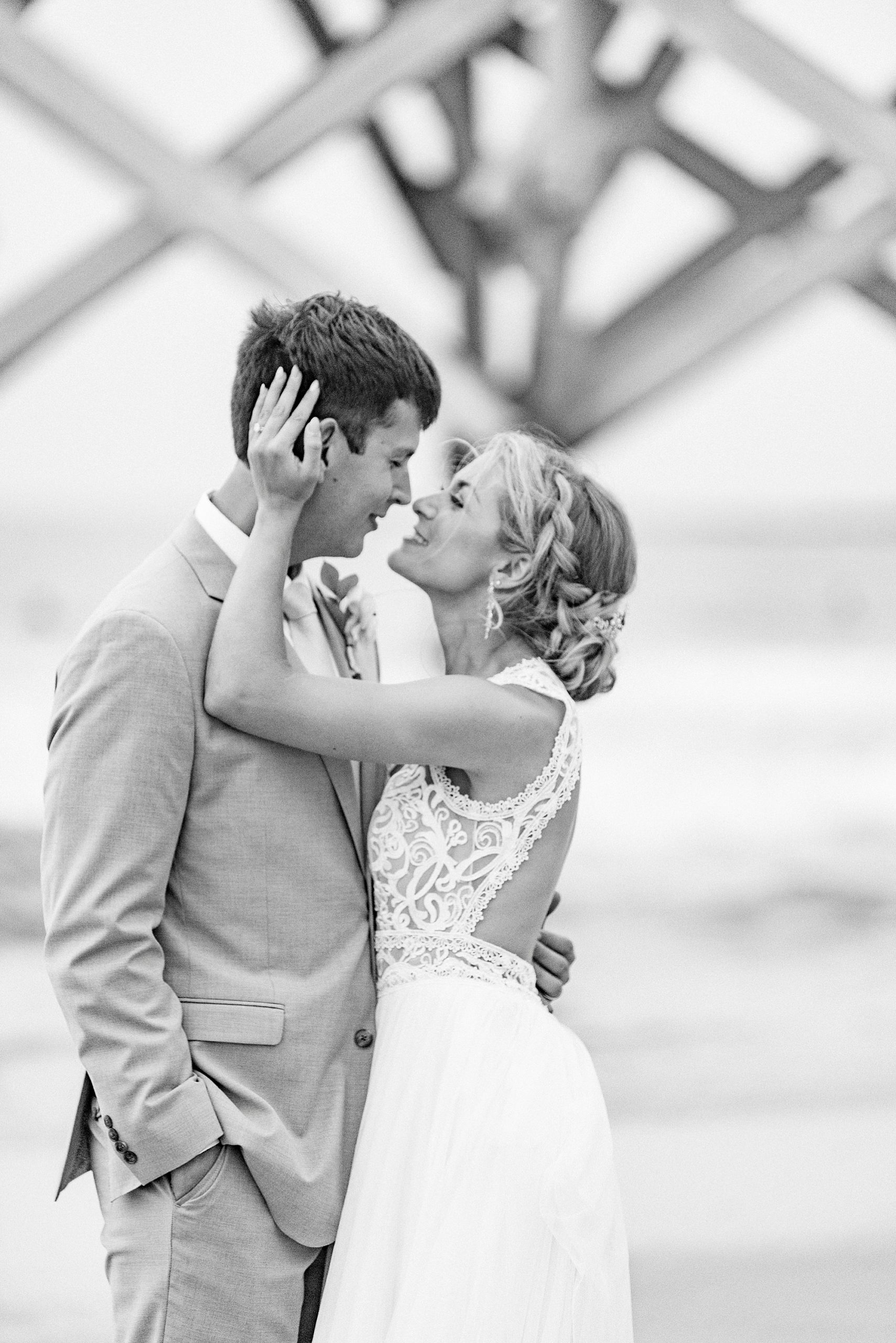 bride touches groom's head during wedding photos