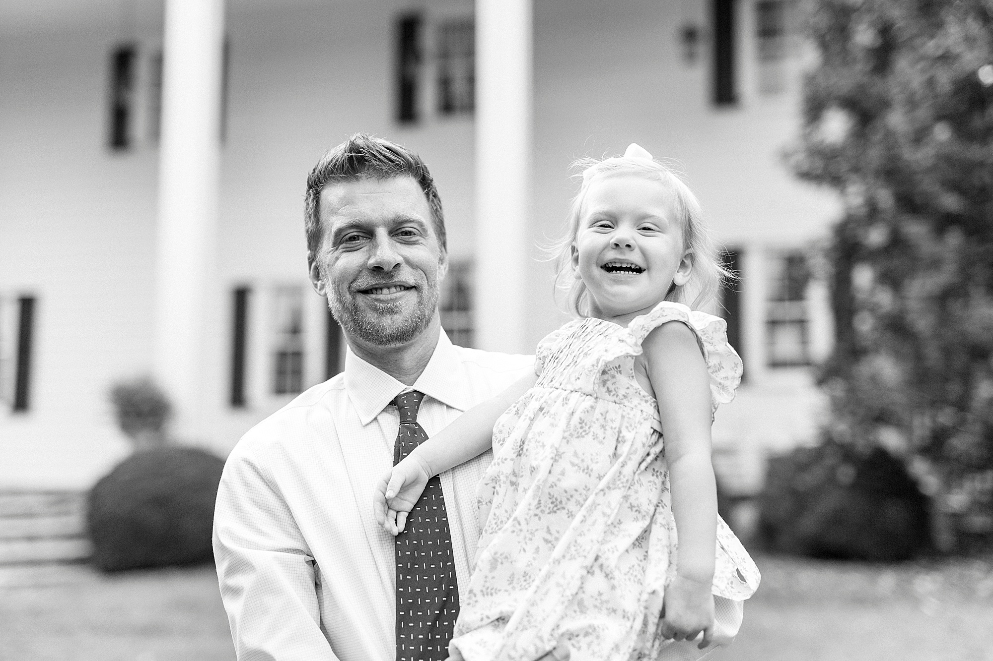 little girl laughs while dad holds her at Vesuvius Vineyards