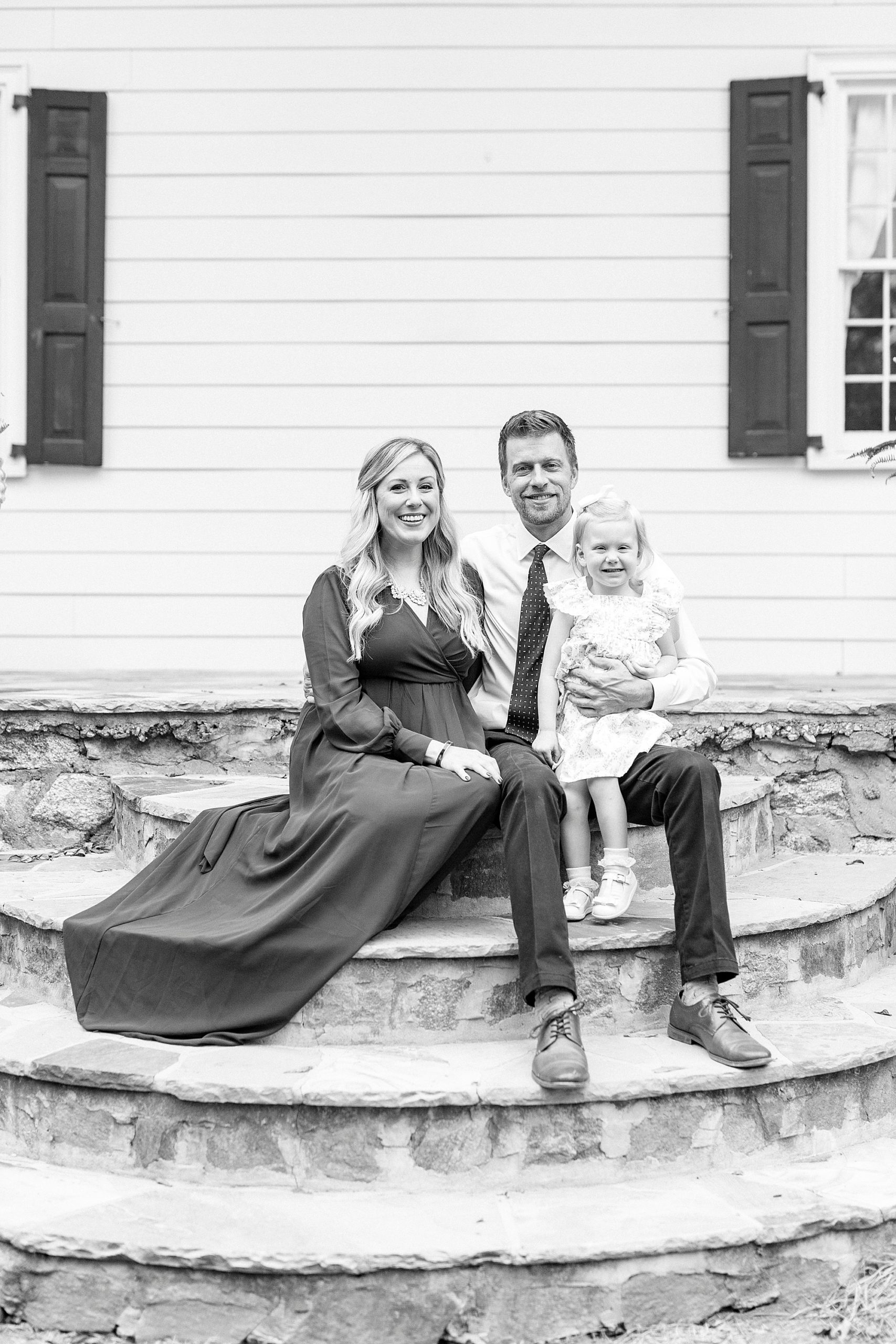 family of three sits on stone steps at Vesuvius Vineyards