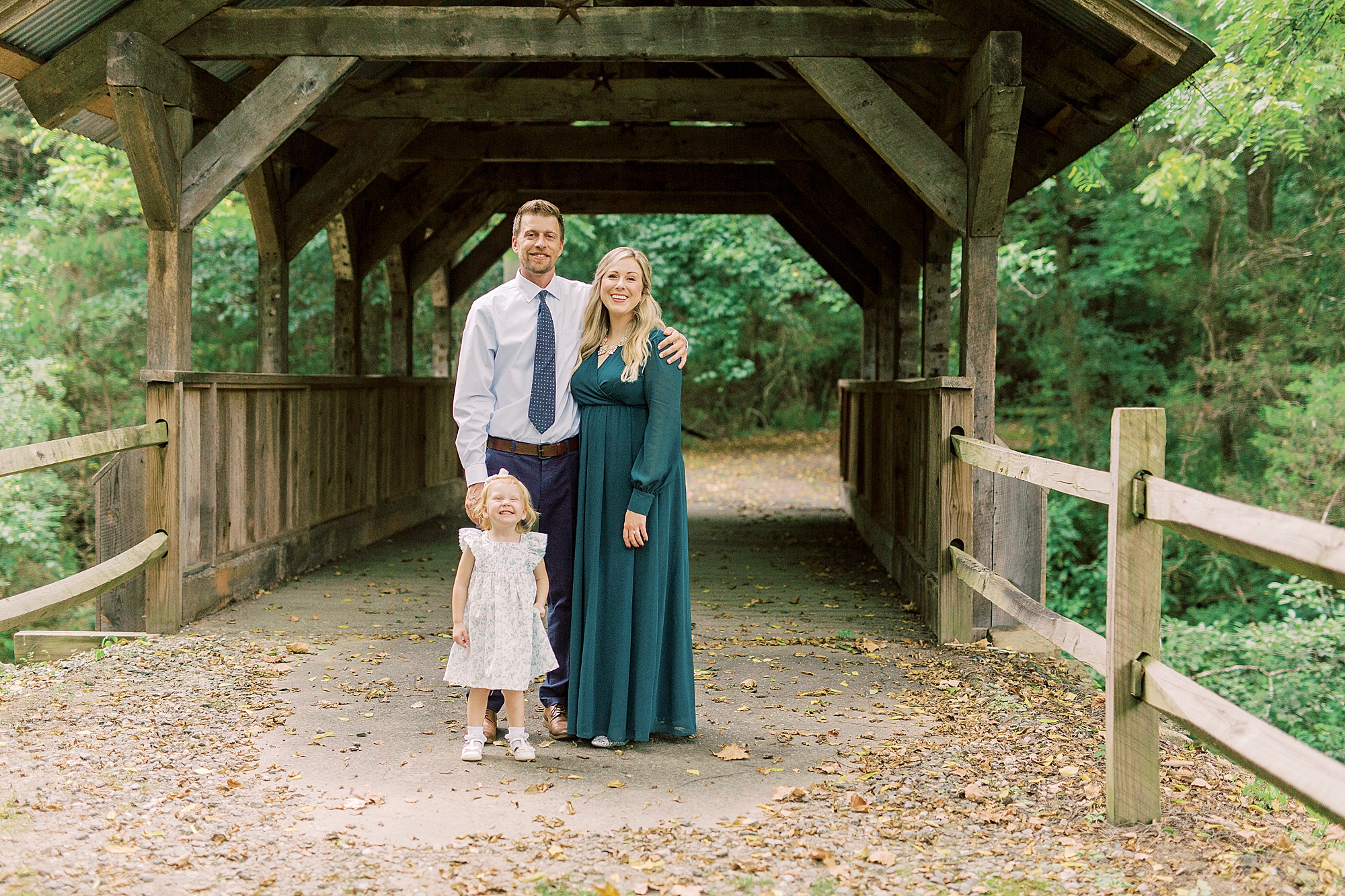 couple poses by covered bridge at Vesuvius Vineyards