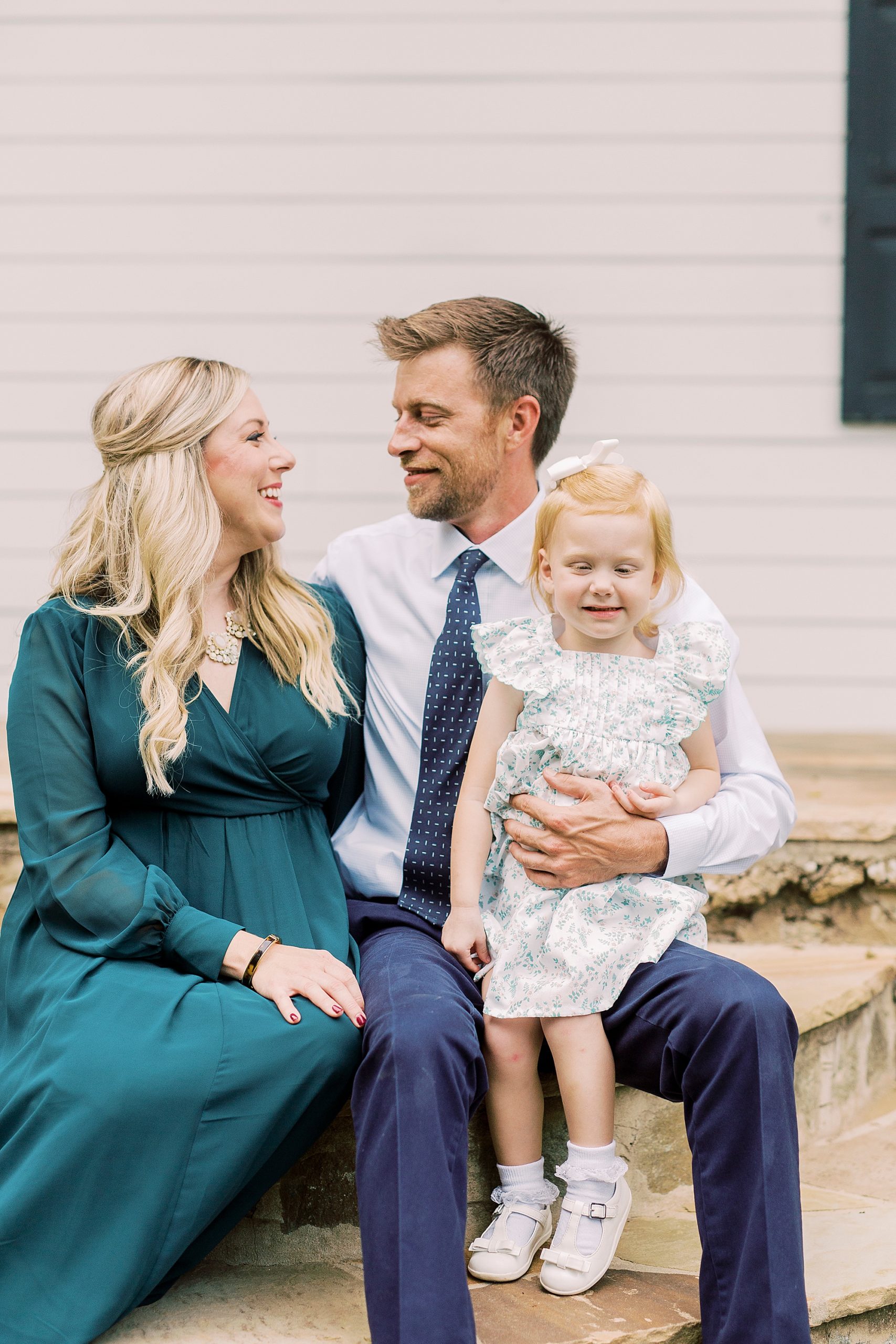 man looks at fiancee while holding daughter during Vesuvius Vineyards engagement session
