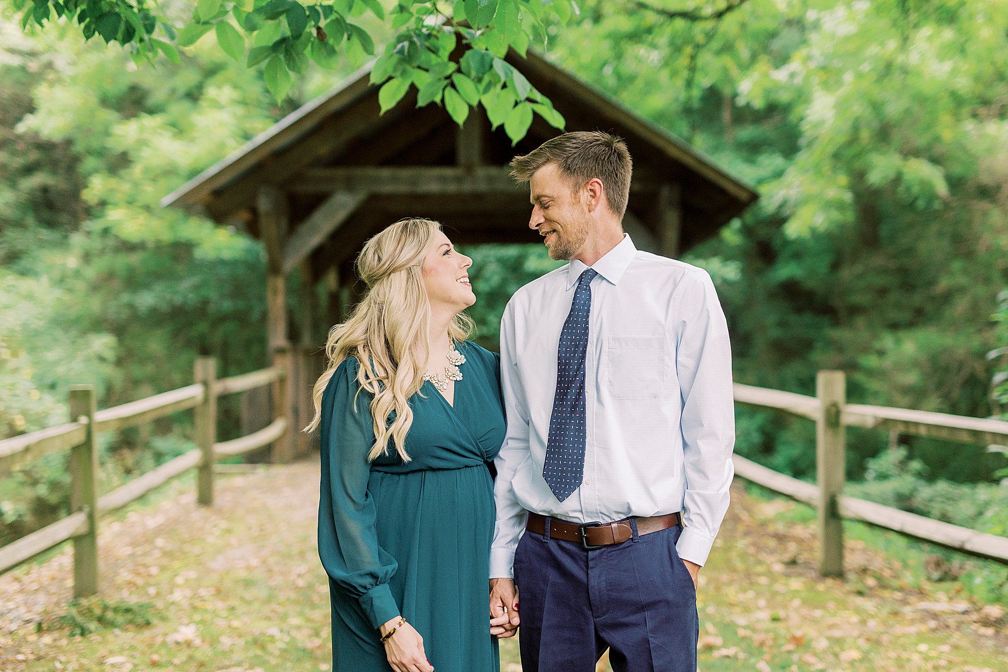 engaged couple looks at each other by bridge at Vesuvius Vineyards