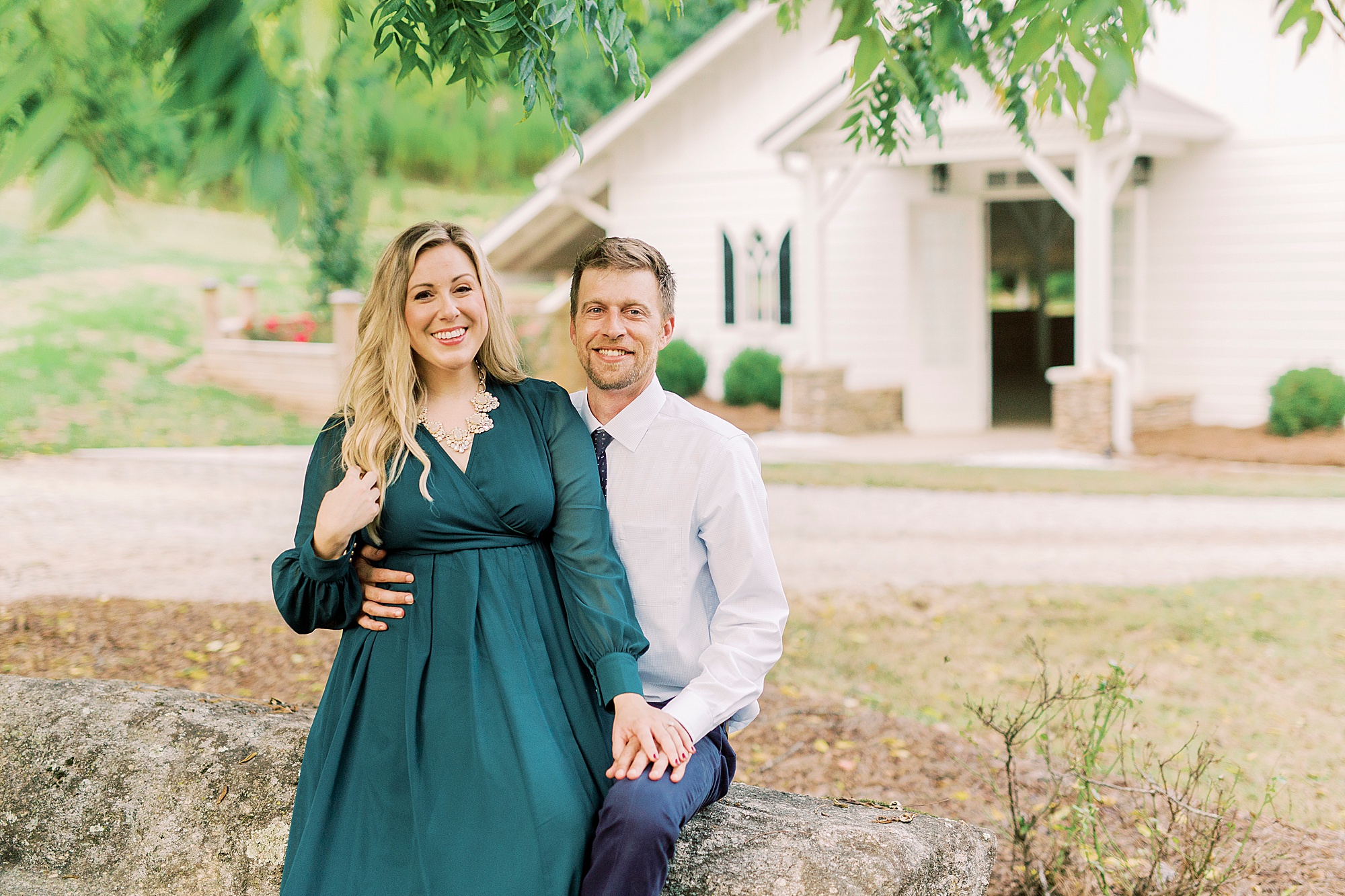 bride and groom sit on stone wall at Vesuvius Vineyards