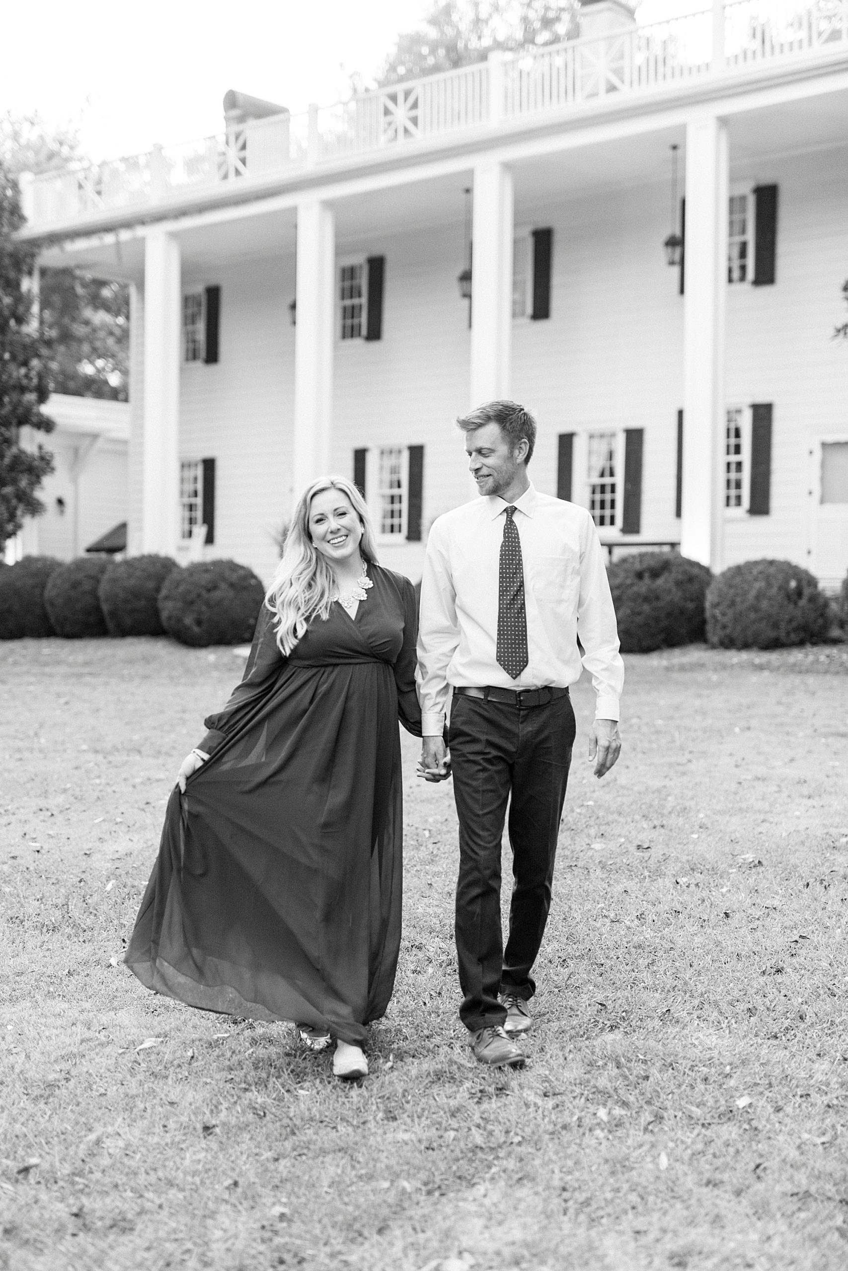 engaged couple walks on lawn at Vesuvius Vineyards
