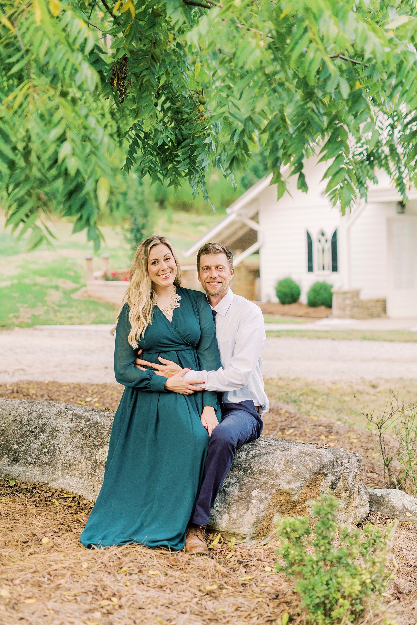 engaged couple sits on stone wall at Vesuvius Vineyards