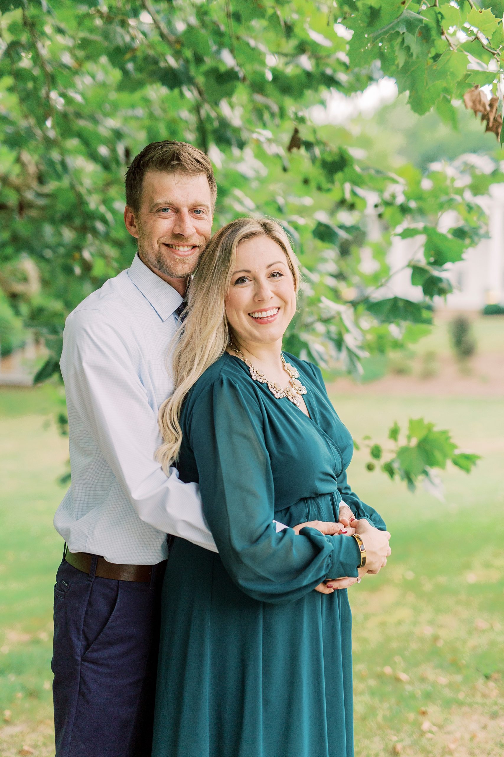 engaged couple stands under trees at Vesuvius Vineyards
