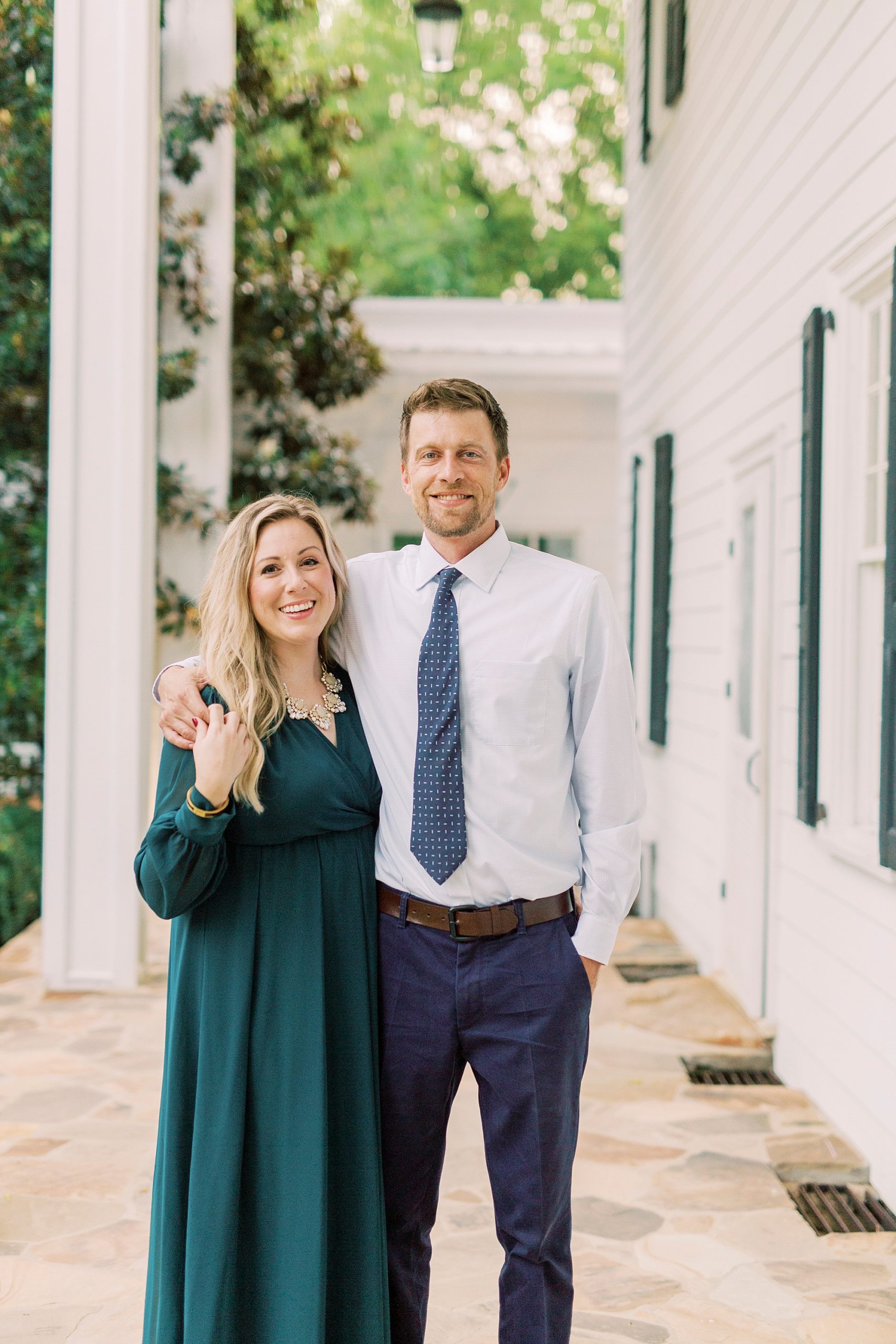 engaged couple walks alongside White House at Vesuvius Vineyards