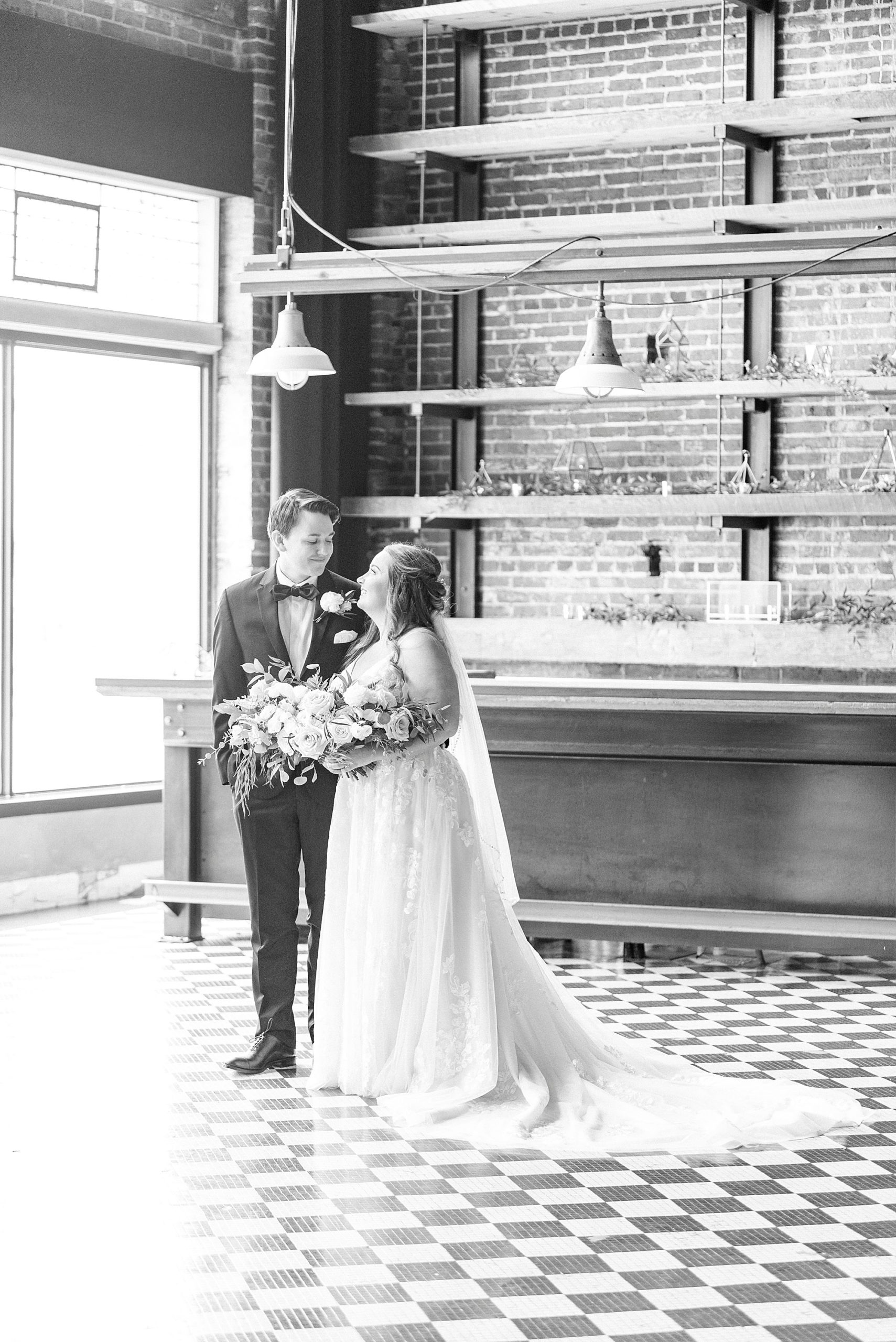 newlyweds look at each other standing in Cadillac Service Garage