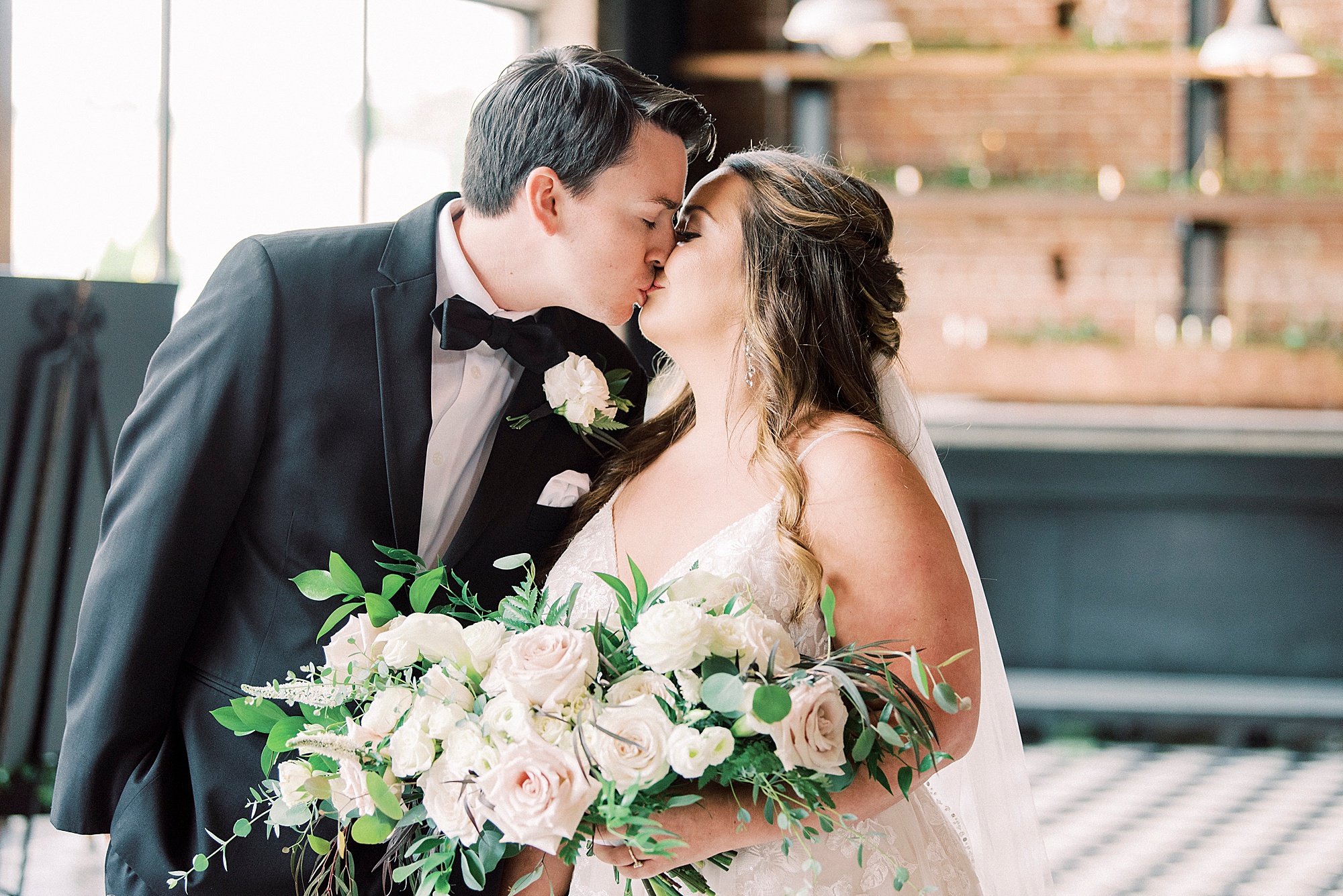 bride and groom kiss inside the Cadillac Service Garage