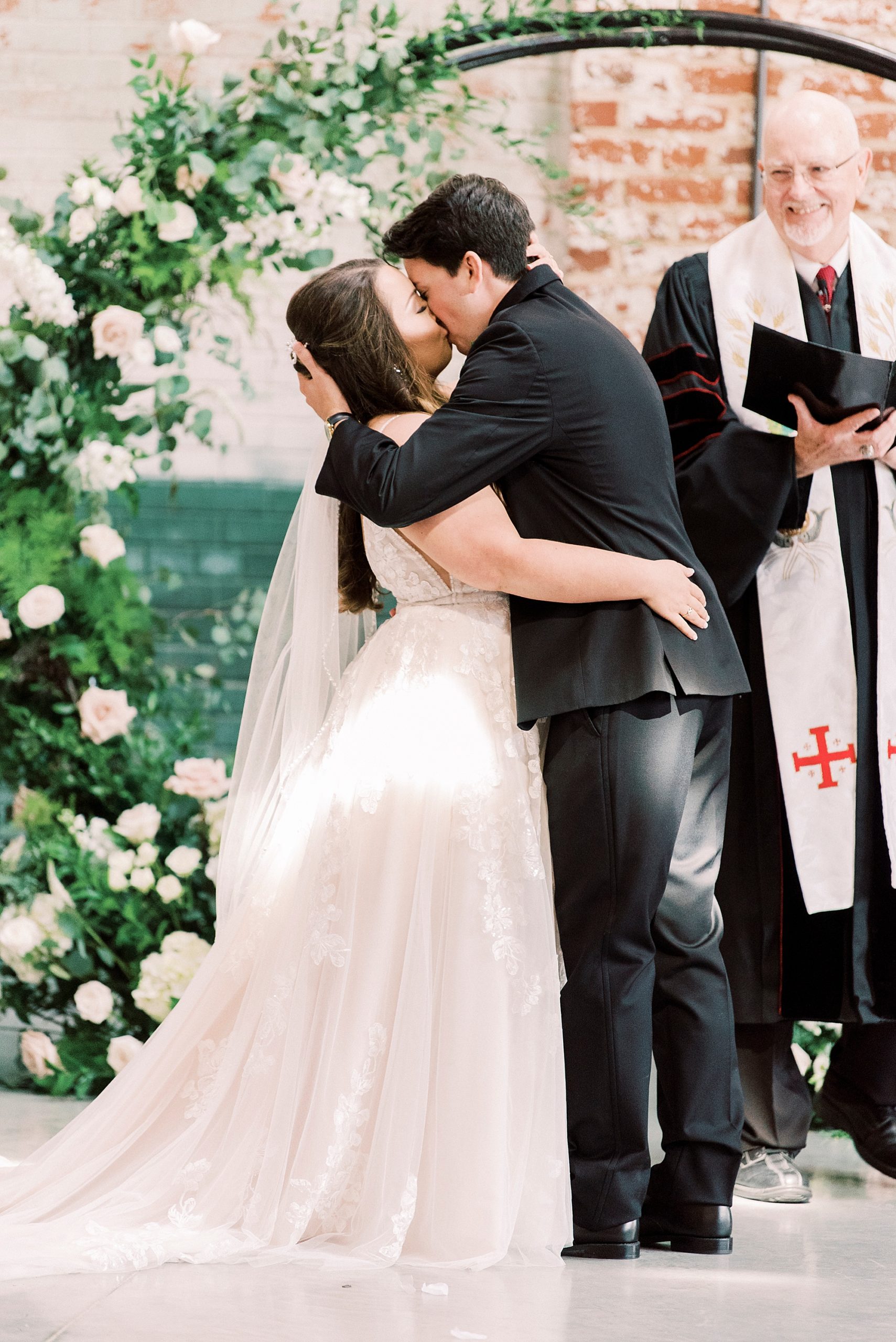 bride and groom kiss during Cadillac Service Garage wedding ceremony