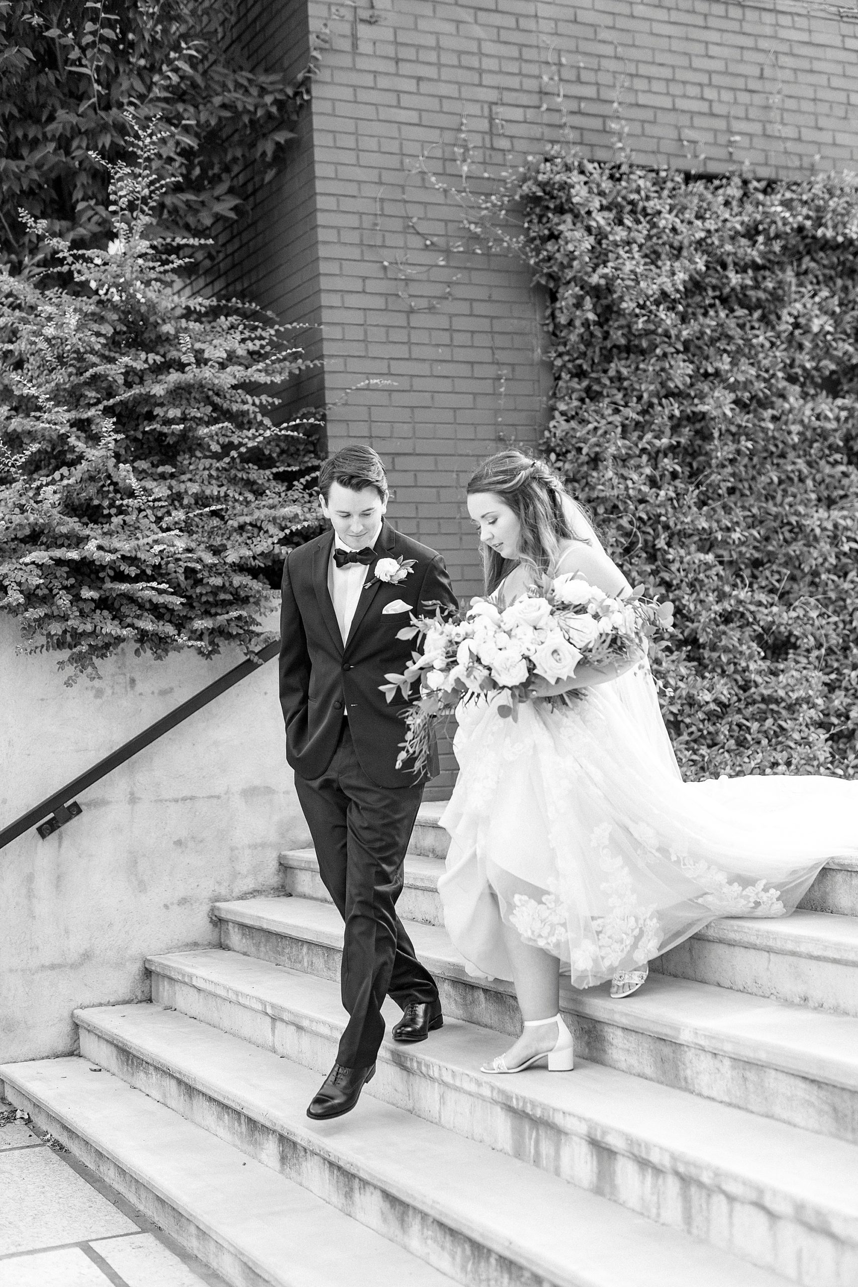 bride and groom walk down steps at the Cadillac Service Garage