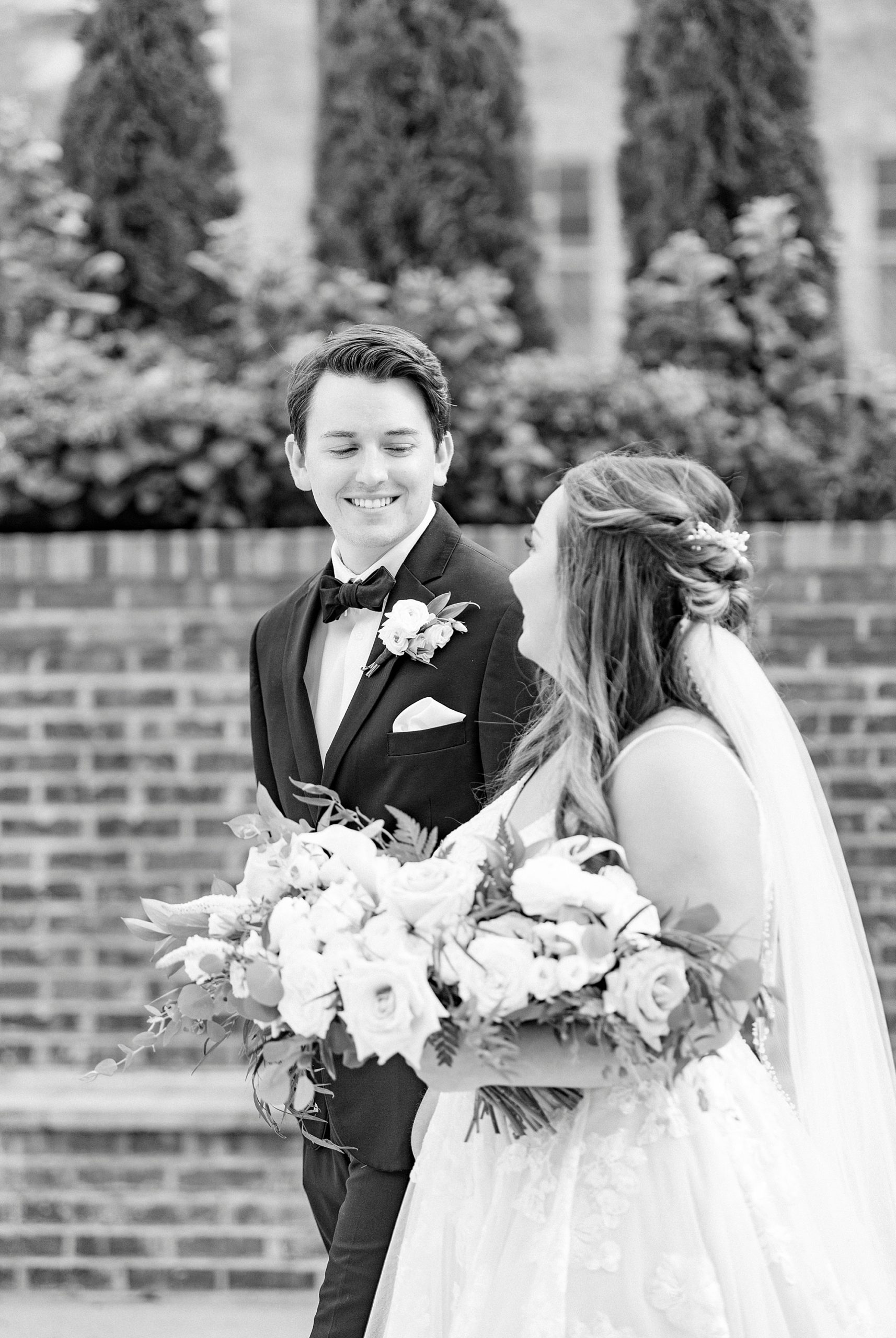 groom looks at bride during wedding portraits at Cadillac Service Garage