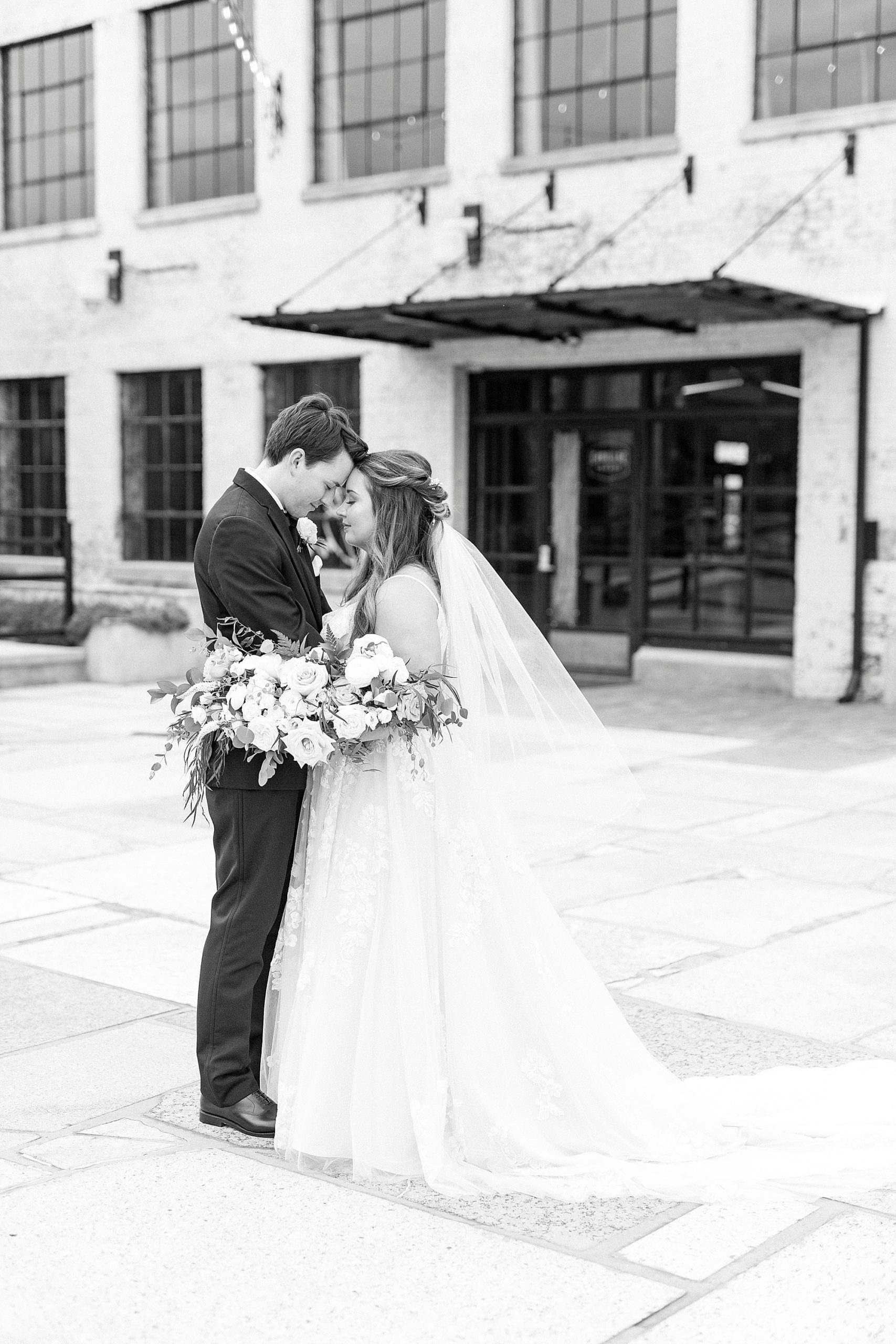 Cadillac Service Garage wedding portraits of bride and groom with veil behind bride