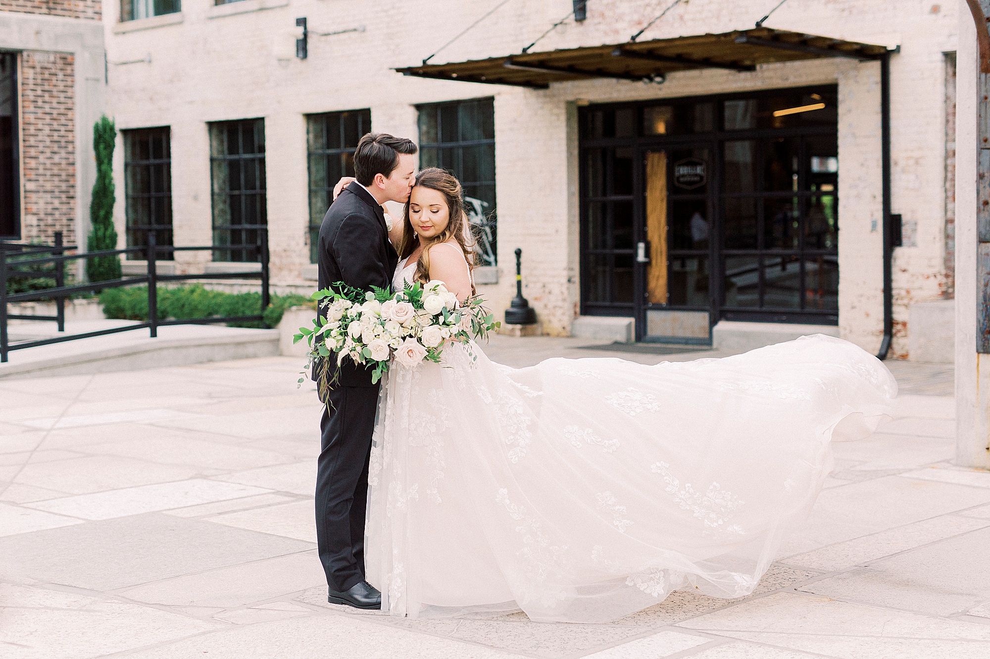 classic bride and groom portraits outside the Cadillac Service Garage
