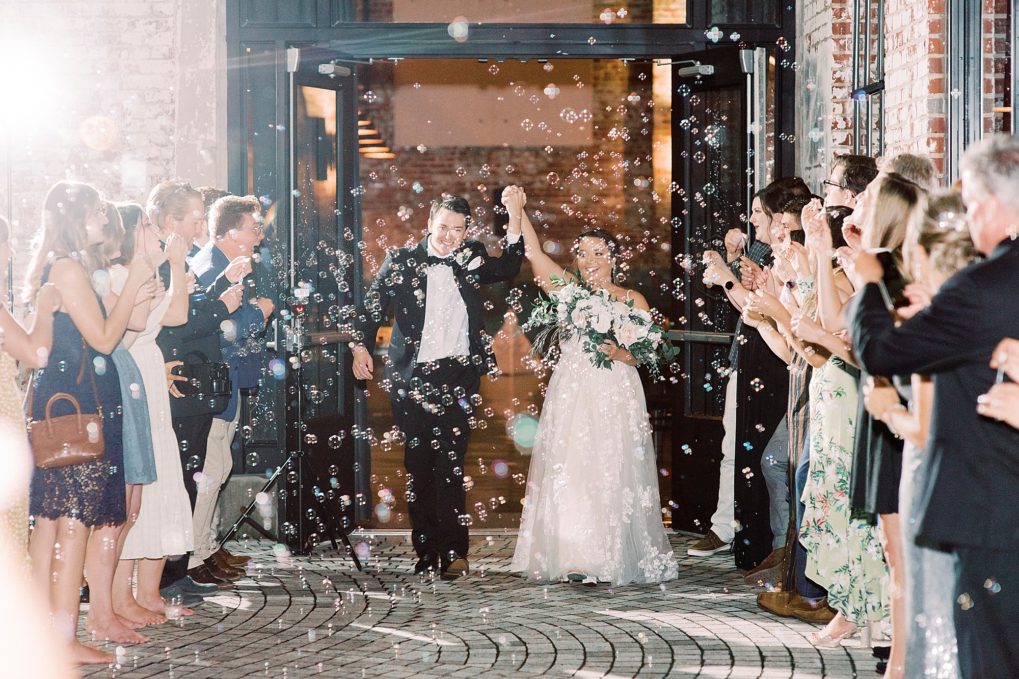 bride and groom cheer during exit from the Cadillac Service Garage