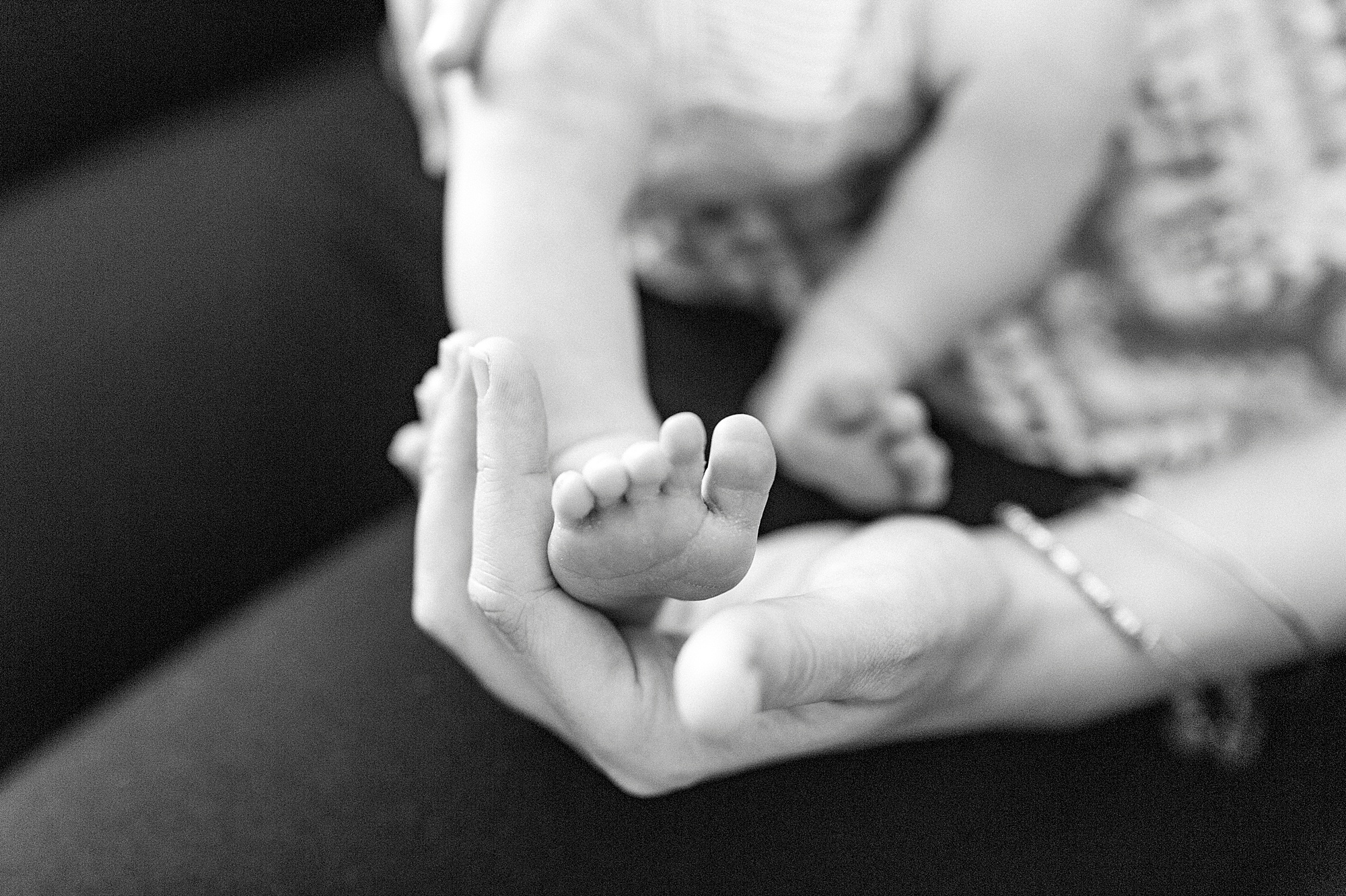 mom holds baby's foot during lifestyle newborn session